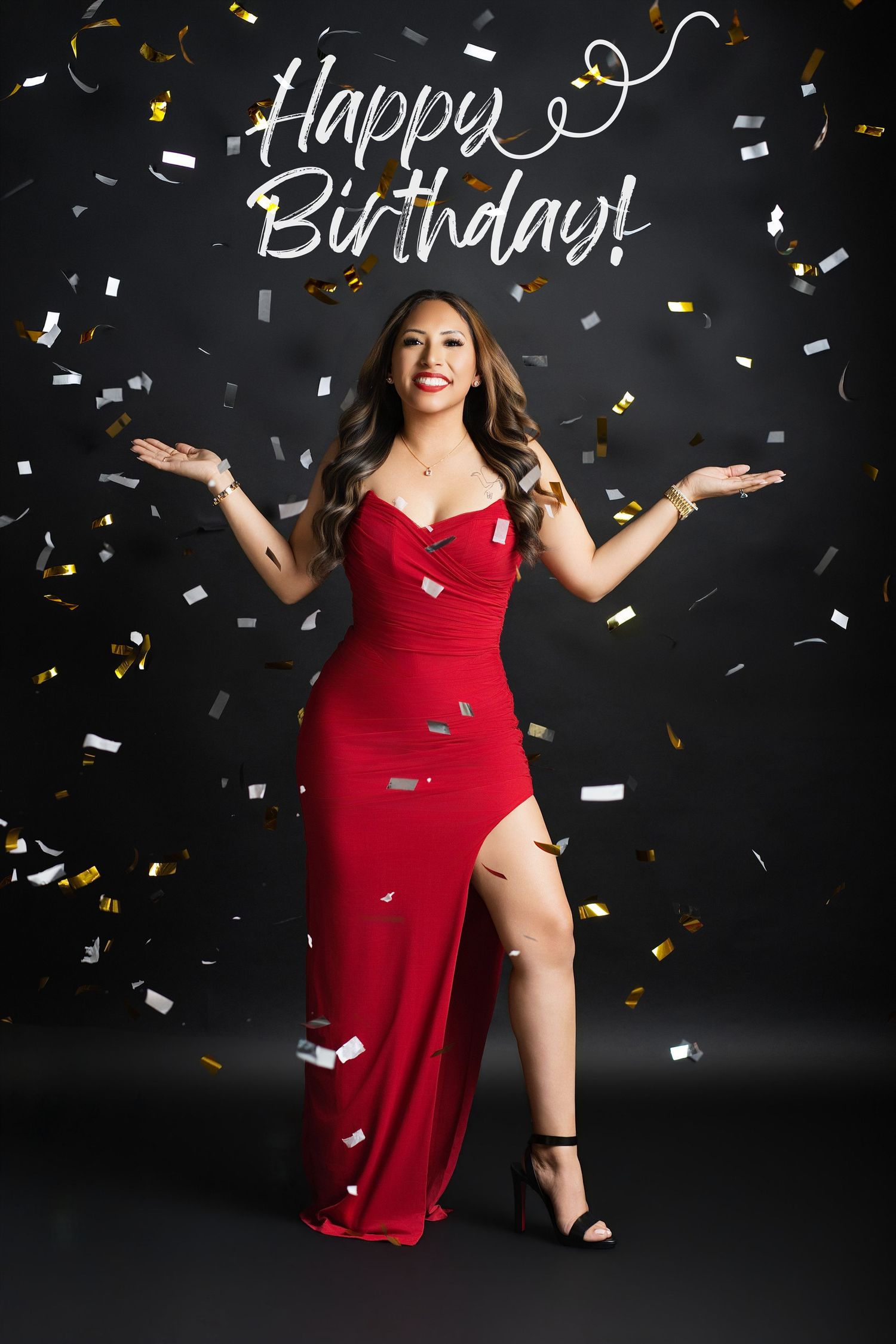 Woman in red gown celebrating birthday with gold and silver confetti on black background.