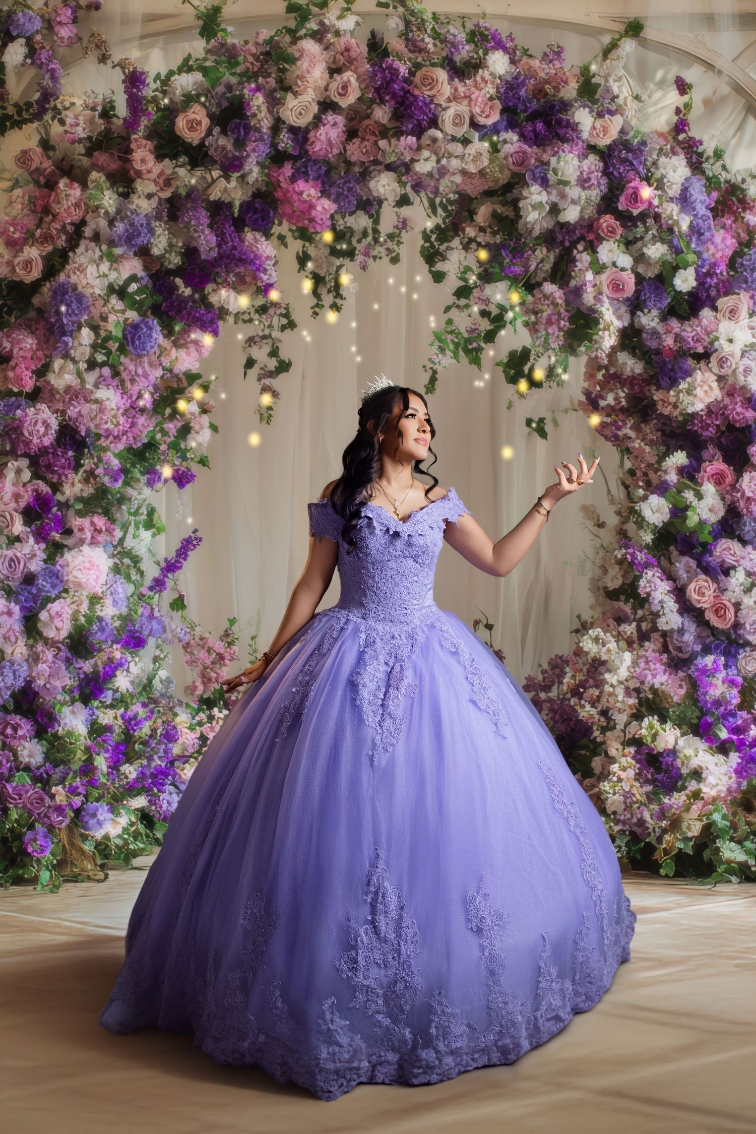 Young woman in lavender ball gown poses before floral arch with purple and pink blooms at quinceañera.