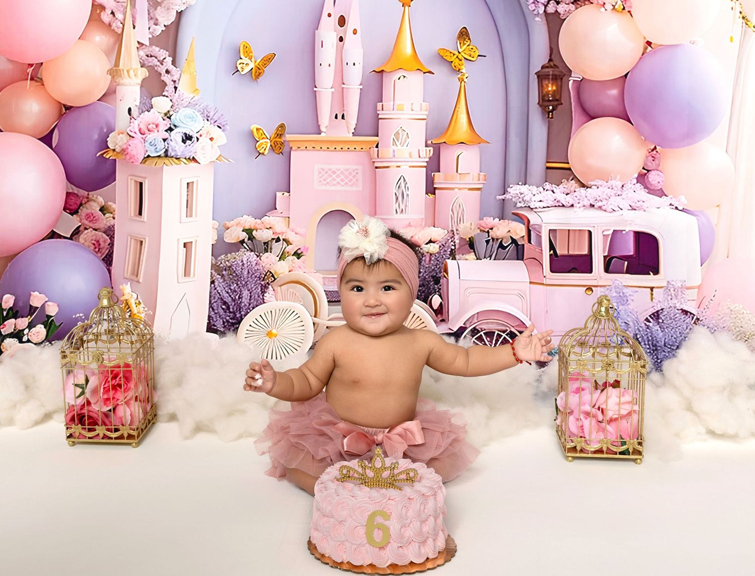 Baby girl in pink tutu celebrates 1st birthday with princess castle backdrop, balloons, and smash cake.
