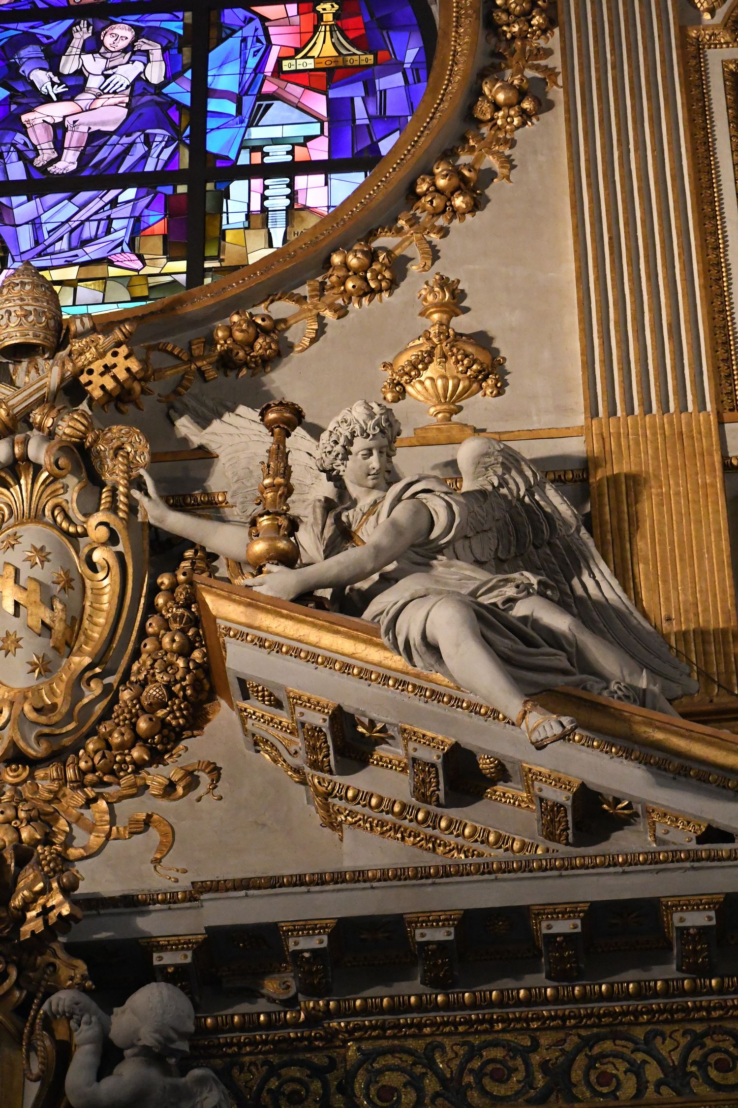 Elaborate baroque church interior with stained glass, gold ornaments, and sculptural details.