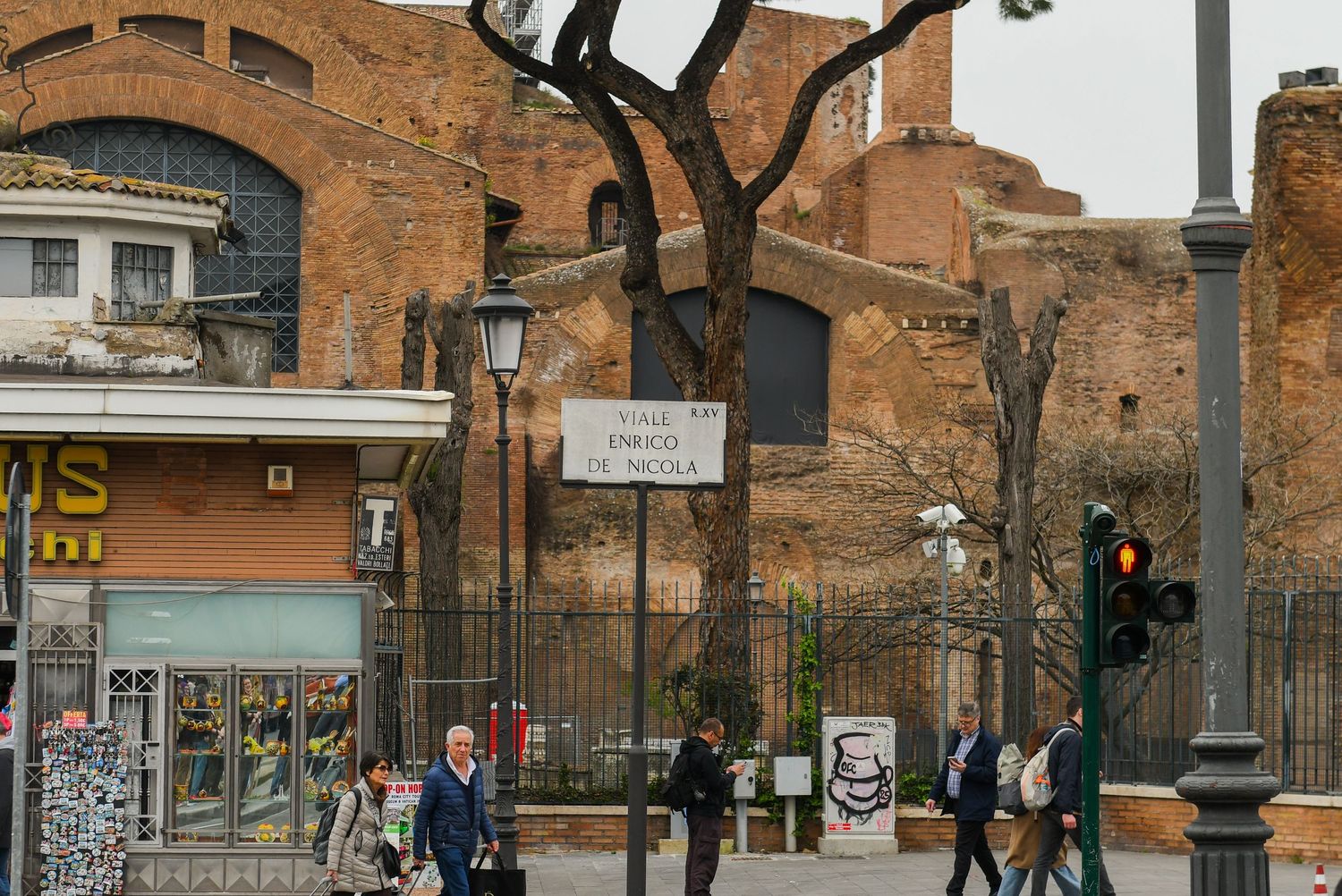 Historic brick architecture with arched windows and street lamps along an urban sidewalk.