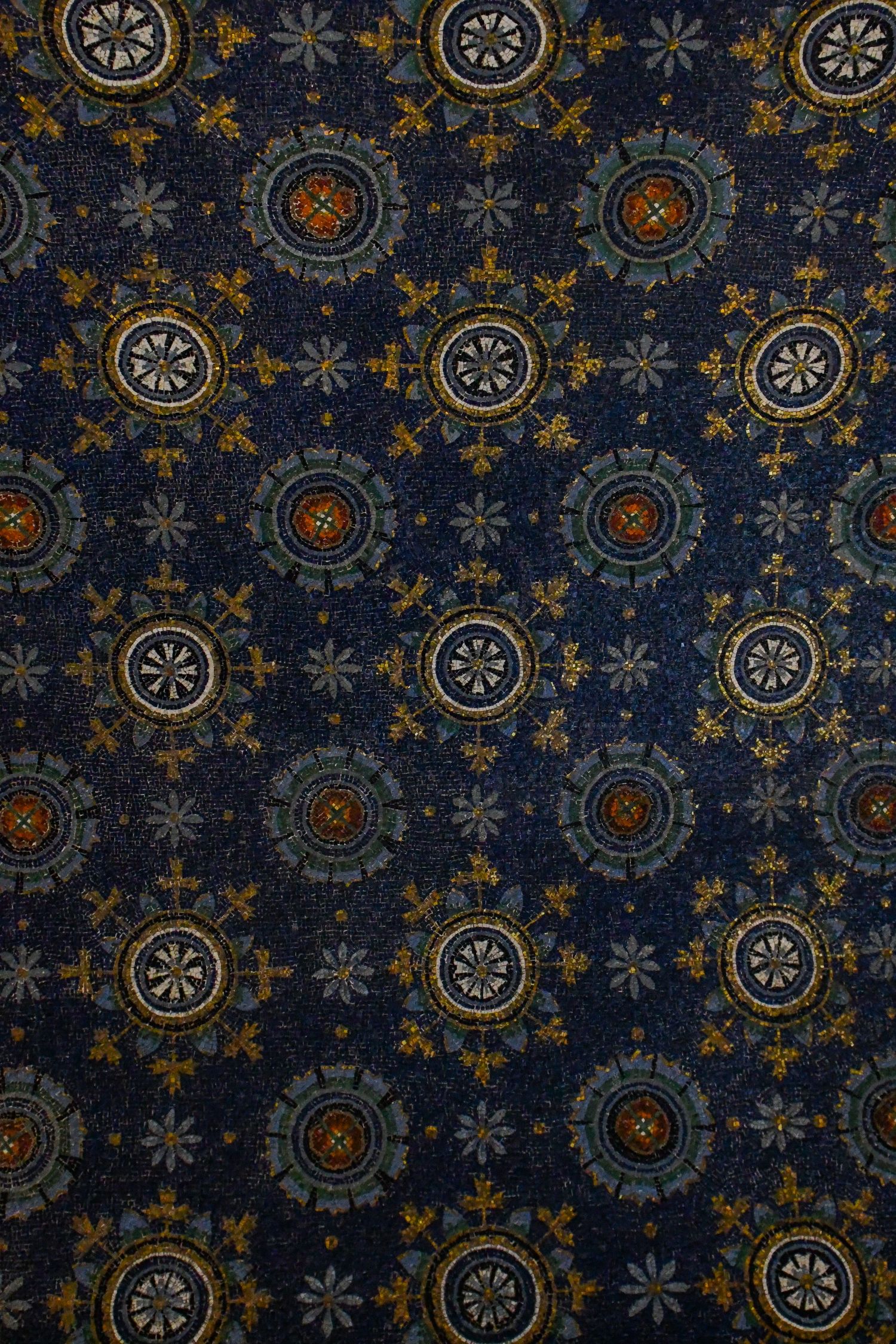 Vintage blue and gold wallpaper pattern featuring repeating circular medallions and floral motifs.