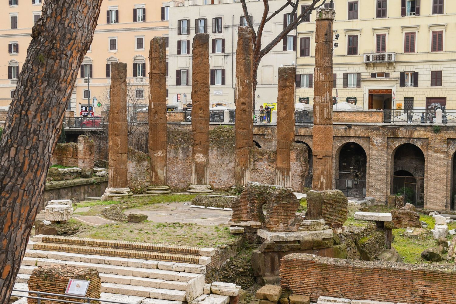 Ancient Roman ruins with stone columns and architectural remains in a courtyard setting.