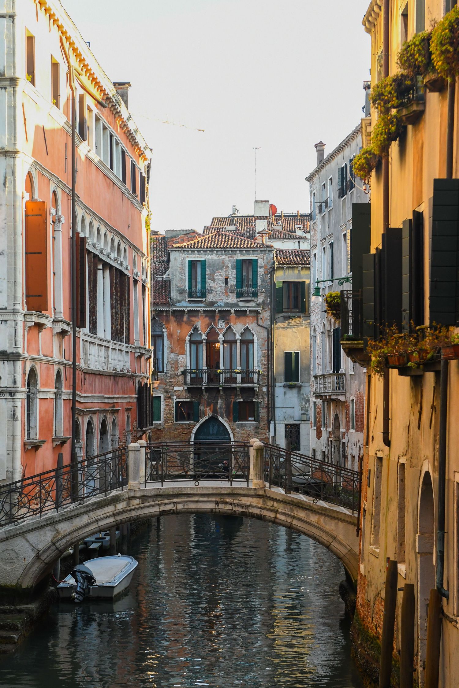 Scenic view of narrow canals and historic bridges in Venice with traditional Italian architecture and reflective waters.