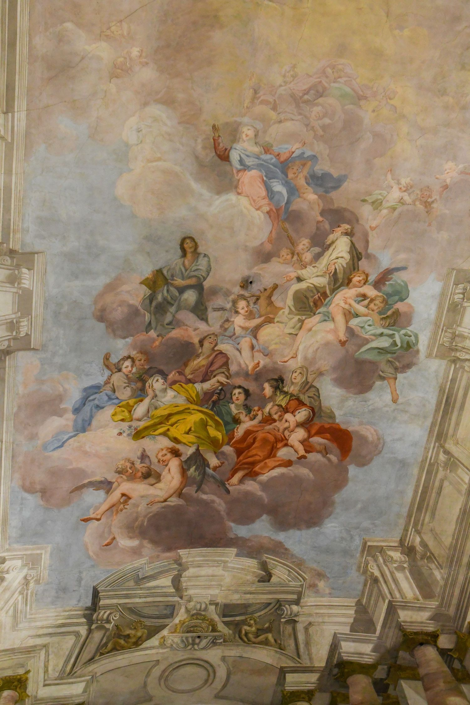 Baroque ceiling fresco depicting angels and mythological figures floating in a cloudy sky with architectural elements.
