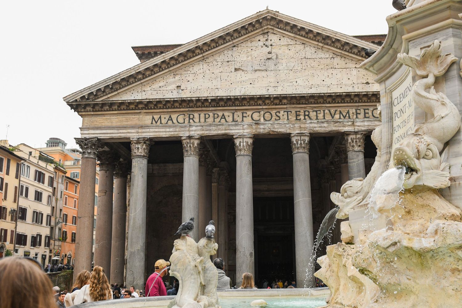 View of the Pantheon's classical facade with its iconic triangular pediment and massive columns in Rome.