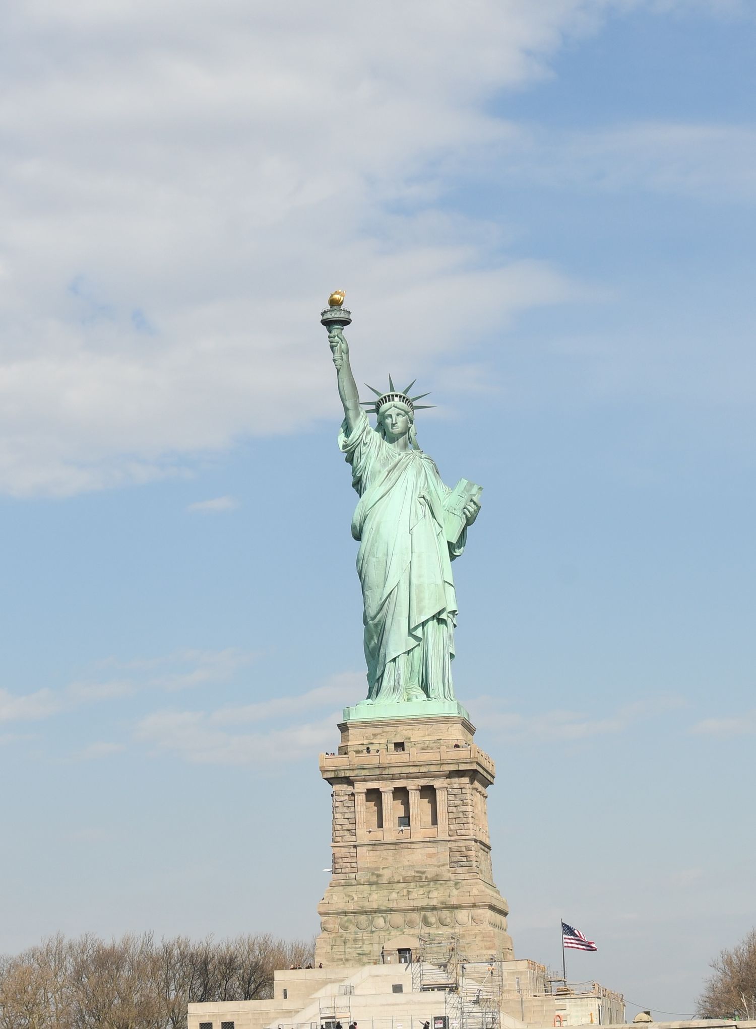 Progressive views of the Statue of Liberty from different angles against a blue sky.