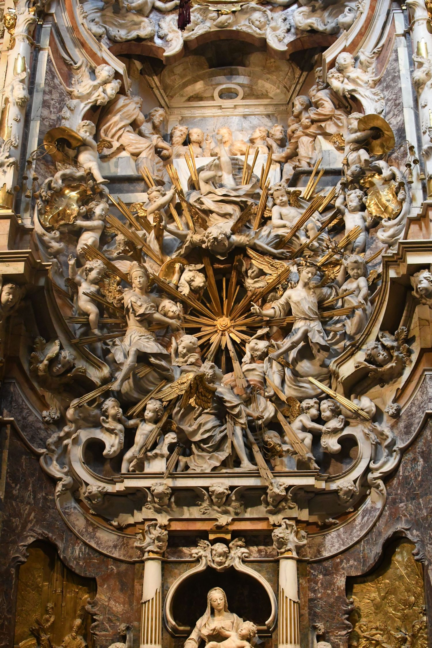 Elaborate baroque church ceiling decoration with gilded cherubs in circular arrangement.
