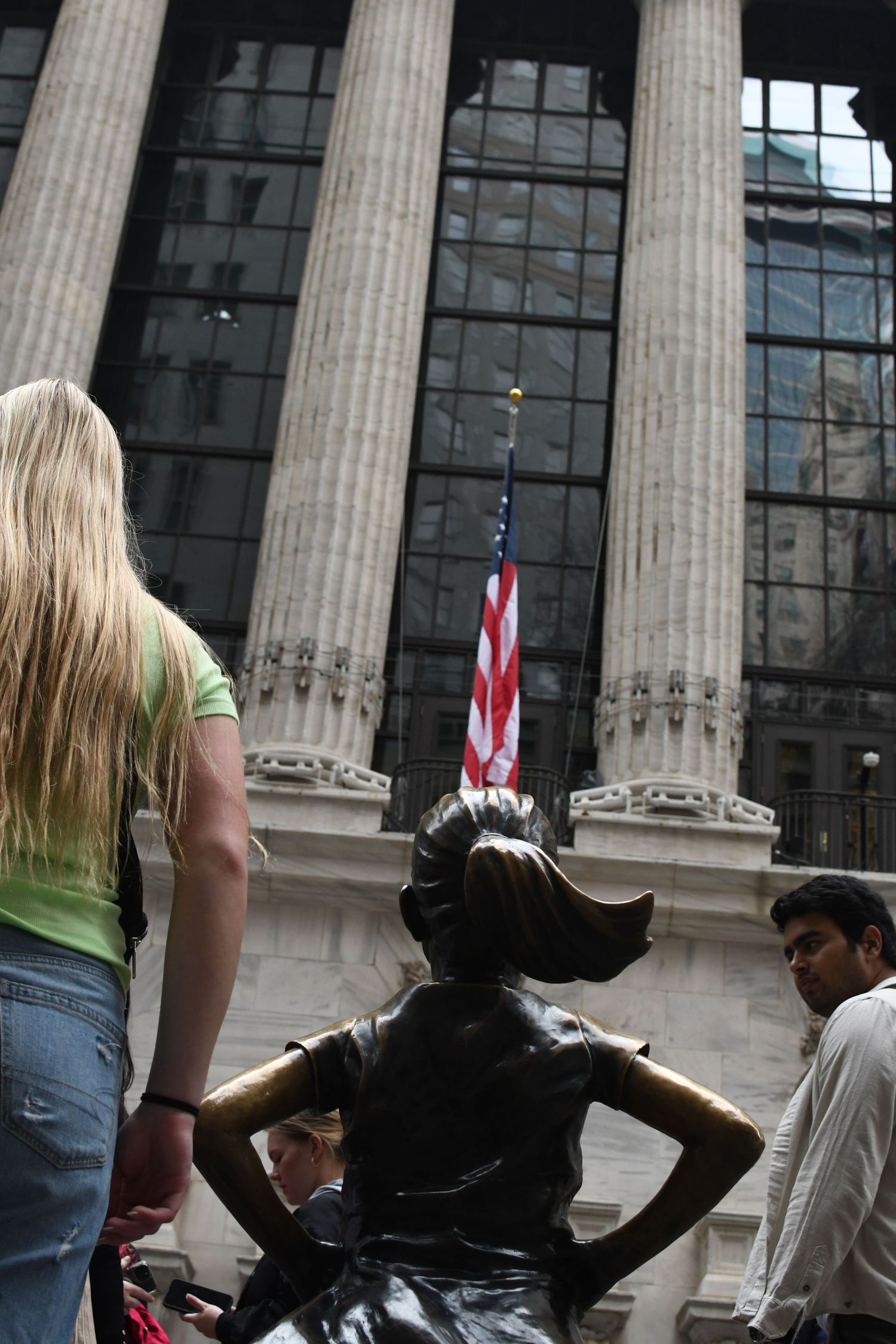 Classical columns frame a bronze bull statue outside the New York Stock Exchange.