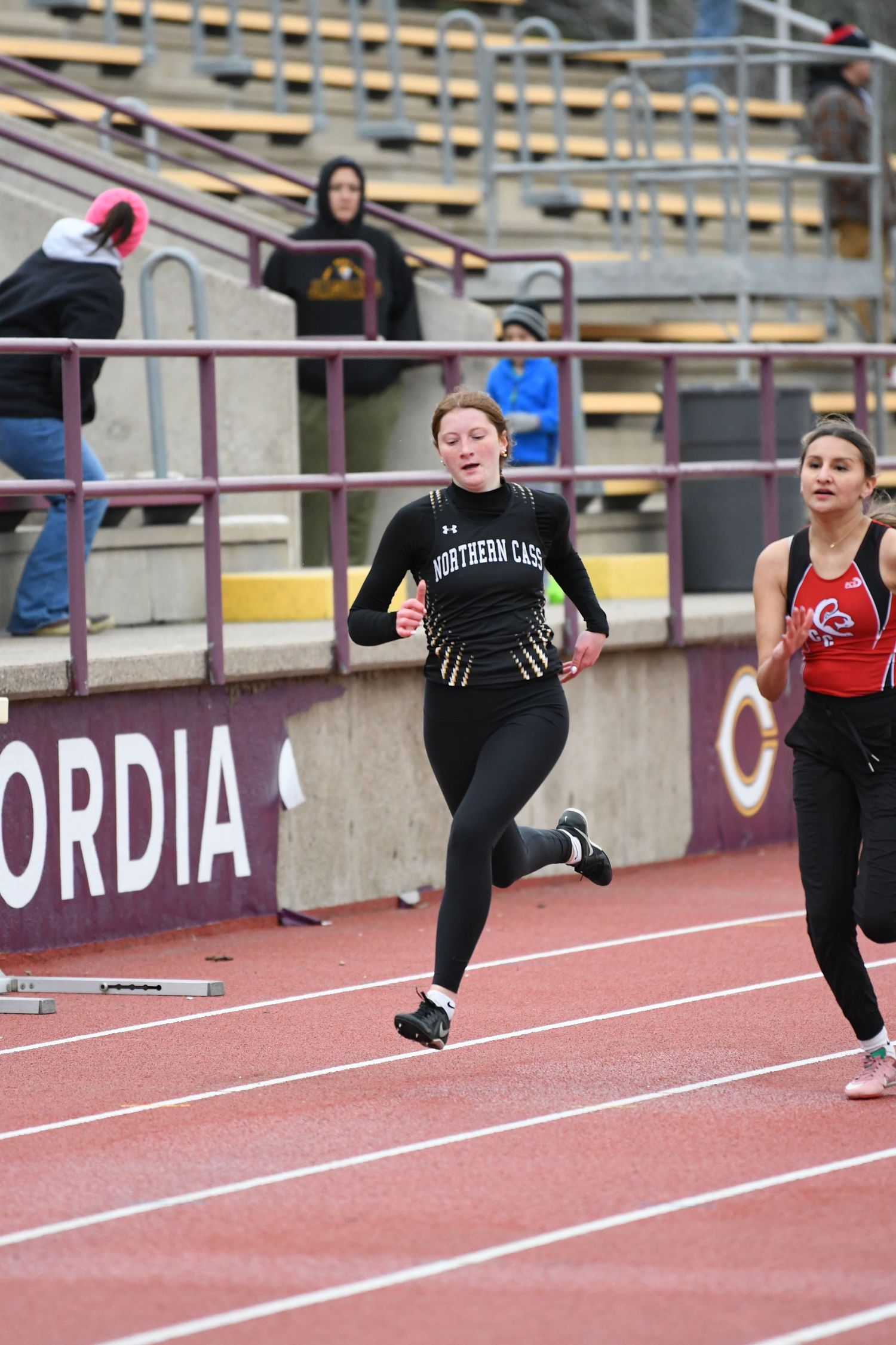 Sprinters compete in close race on outdoor track during athletic meet.