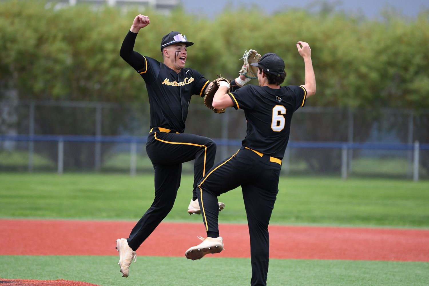 Baseball players in action during game with athletic movements on field.