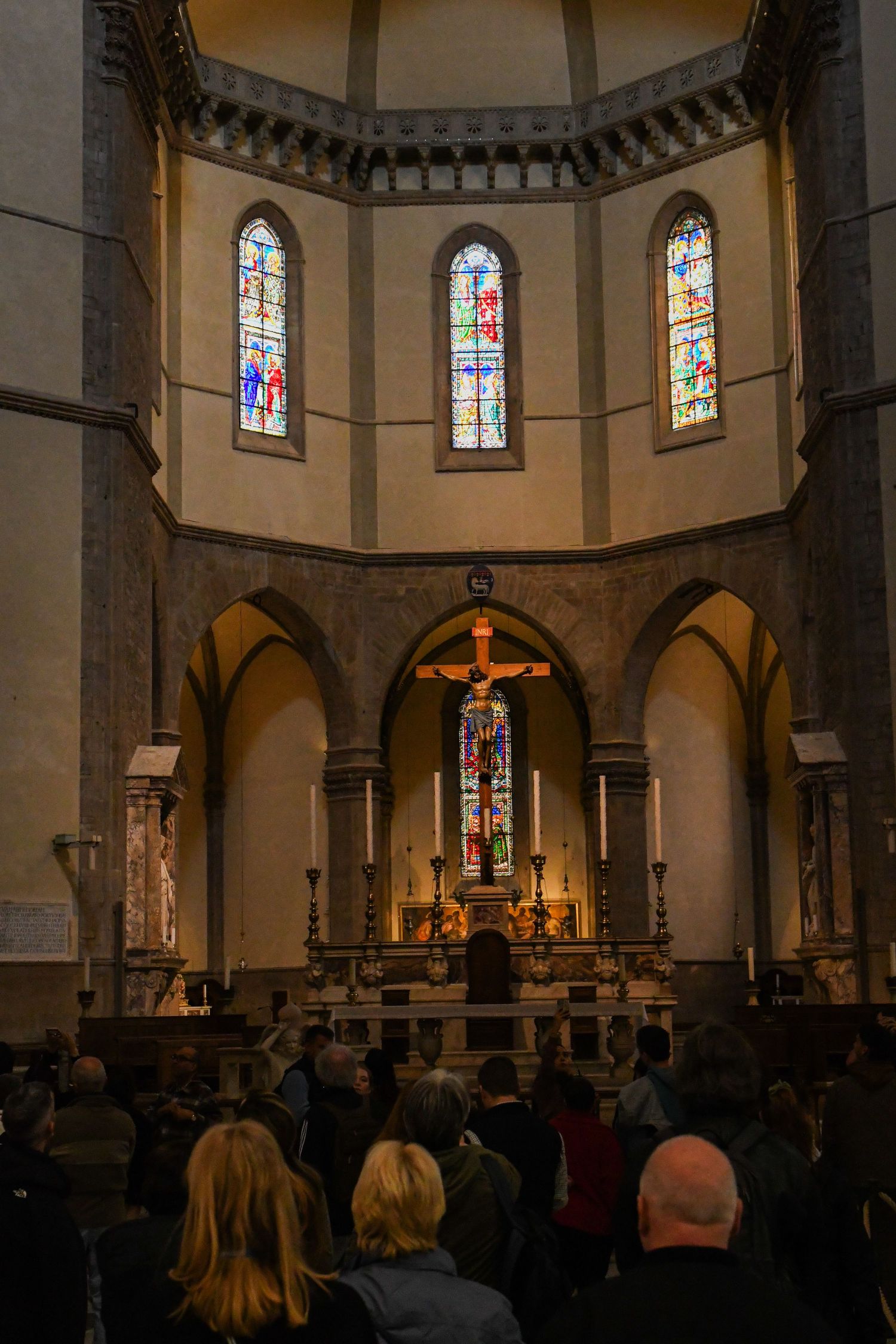 Interior view of a church with stained glass windows and arched architecture during a service.