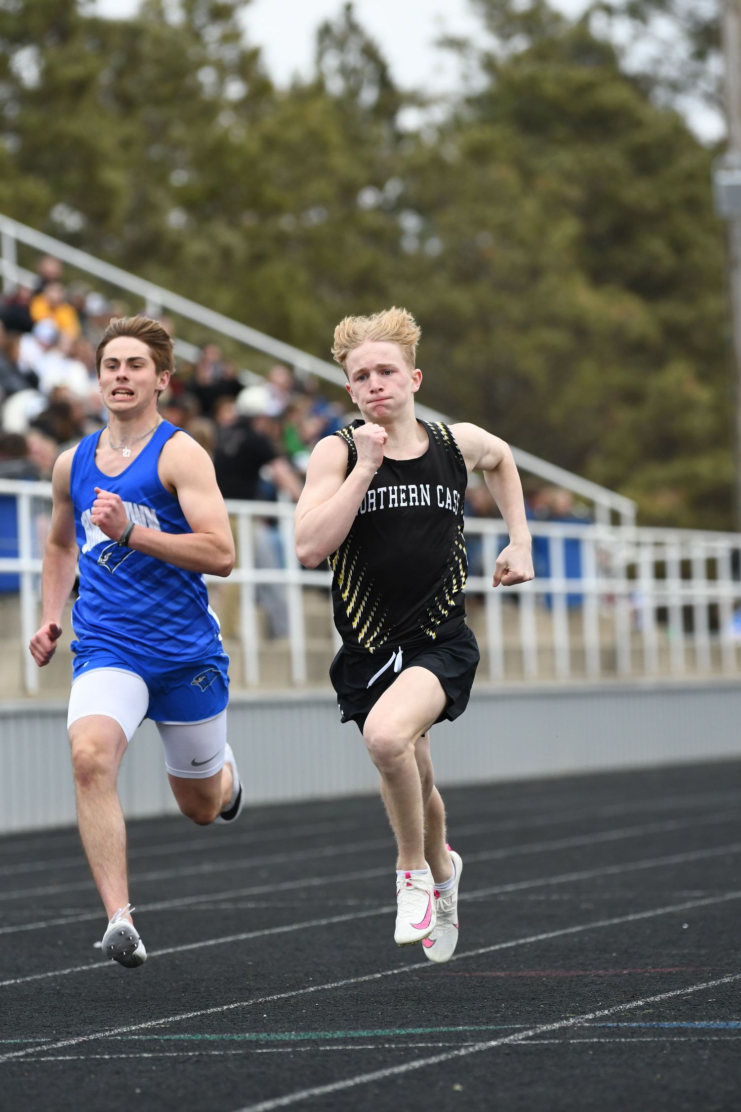 Sprinters accelerate from starting position during track competition.