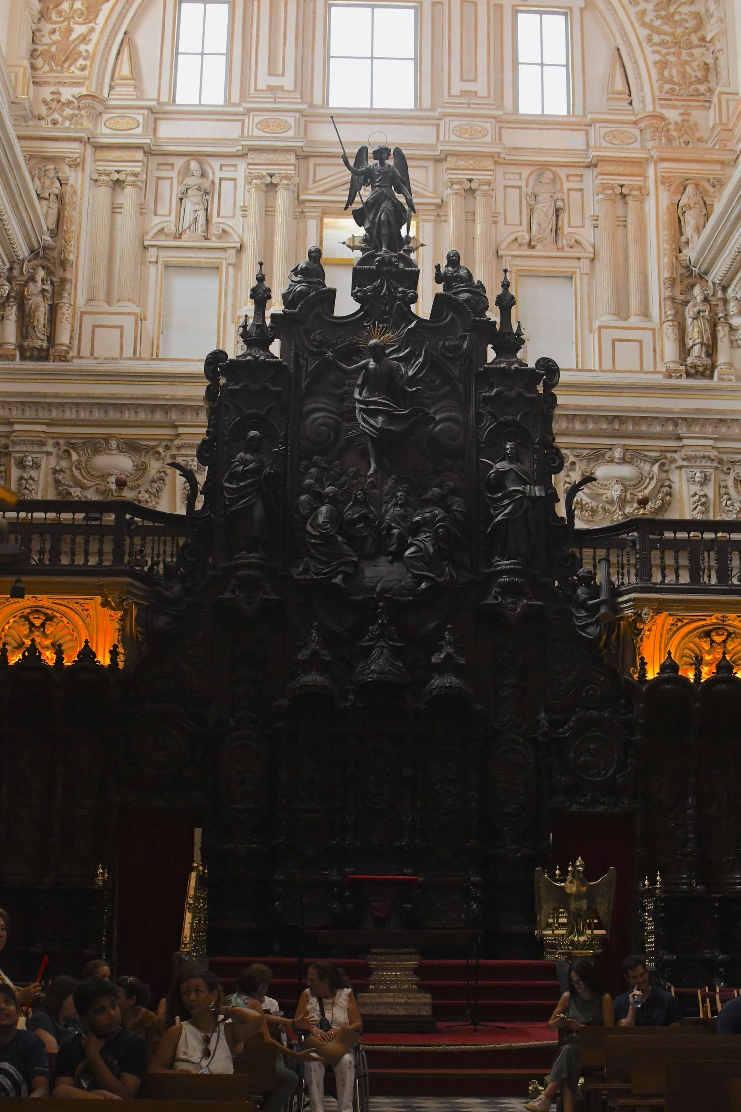 Ornate black gothic altar structure inside a grand cathedral with baroque architectural details.