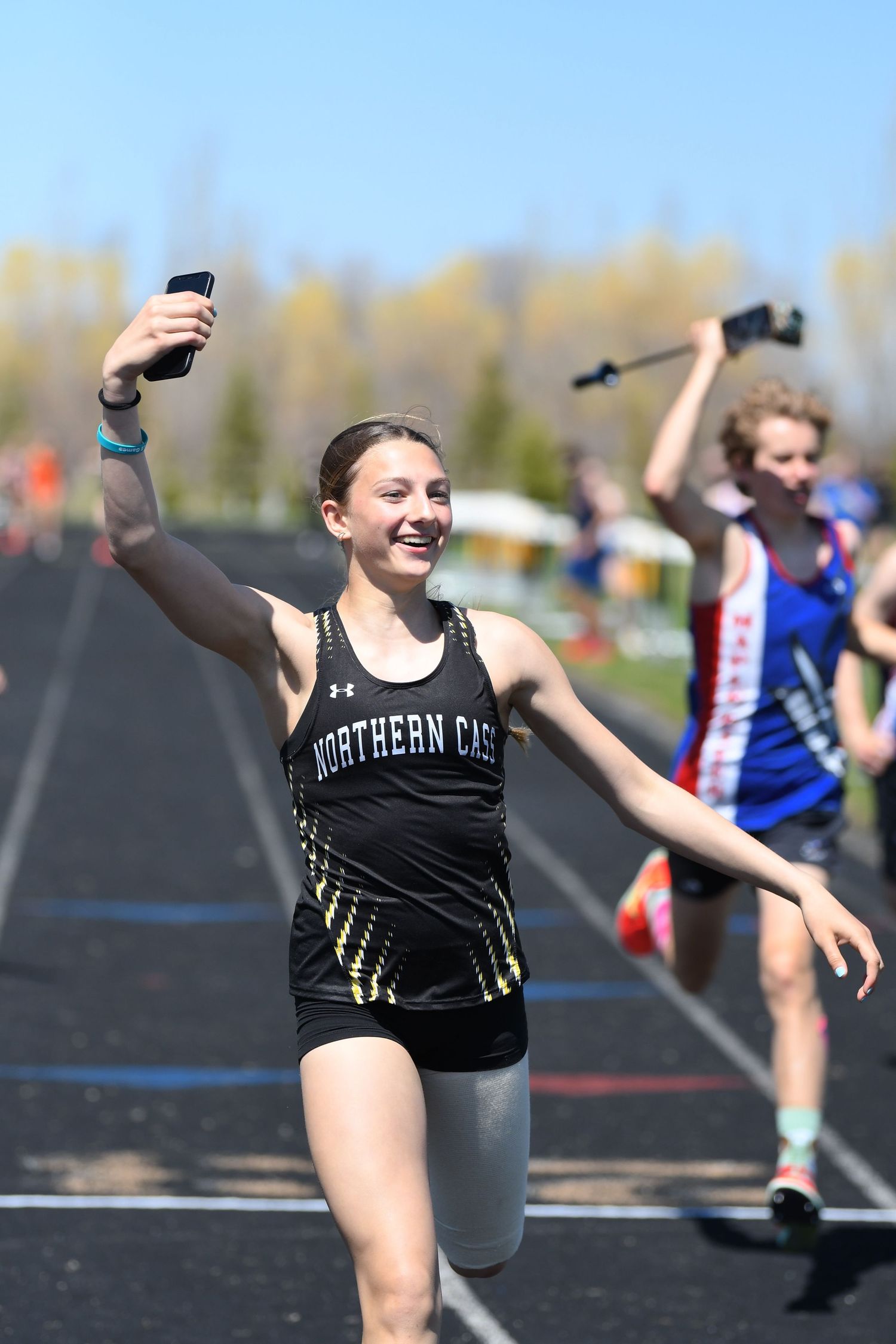 Athlete in black uniform performs graceful dance-like movements during track and field competition.