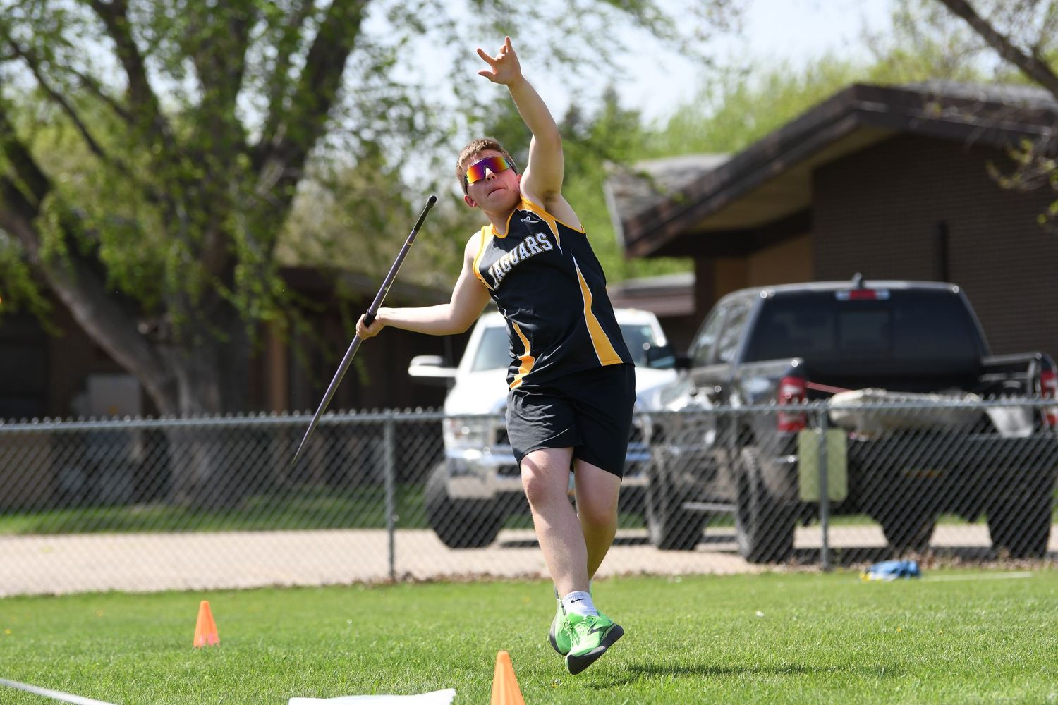 Track athlete competes in discus throw event at outdoor sports venue.