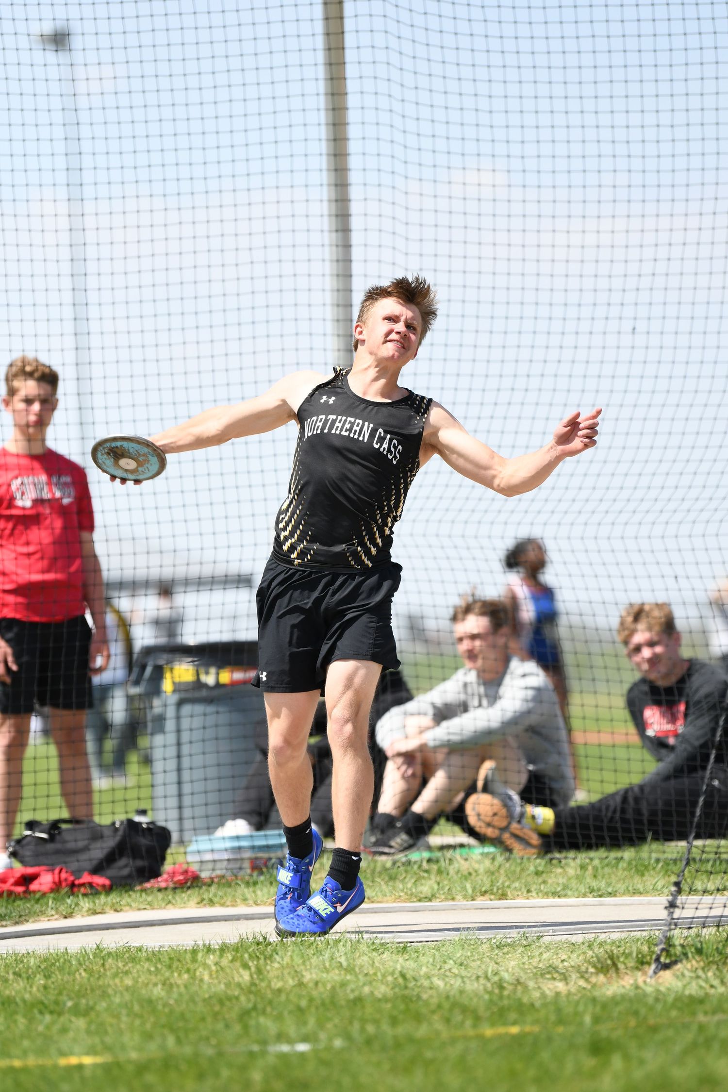 High school athlete performs a discus throw during a track and field competition.