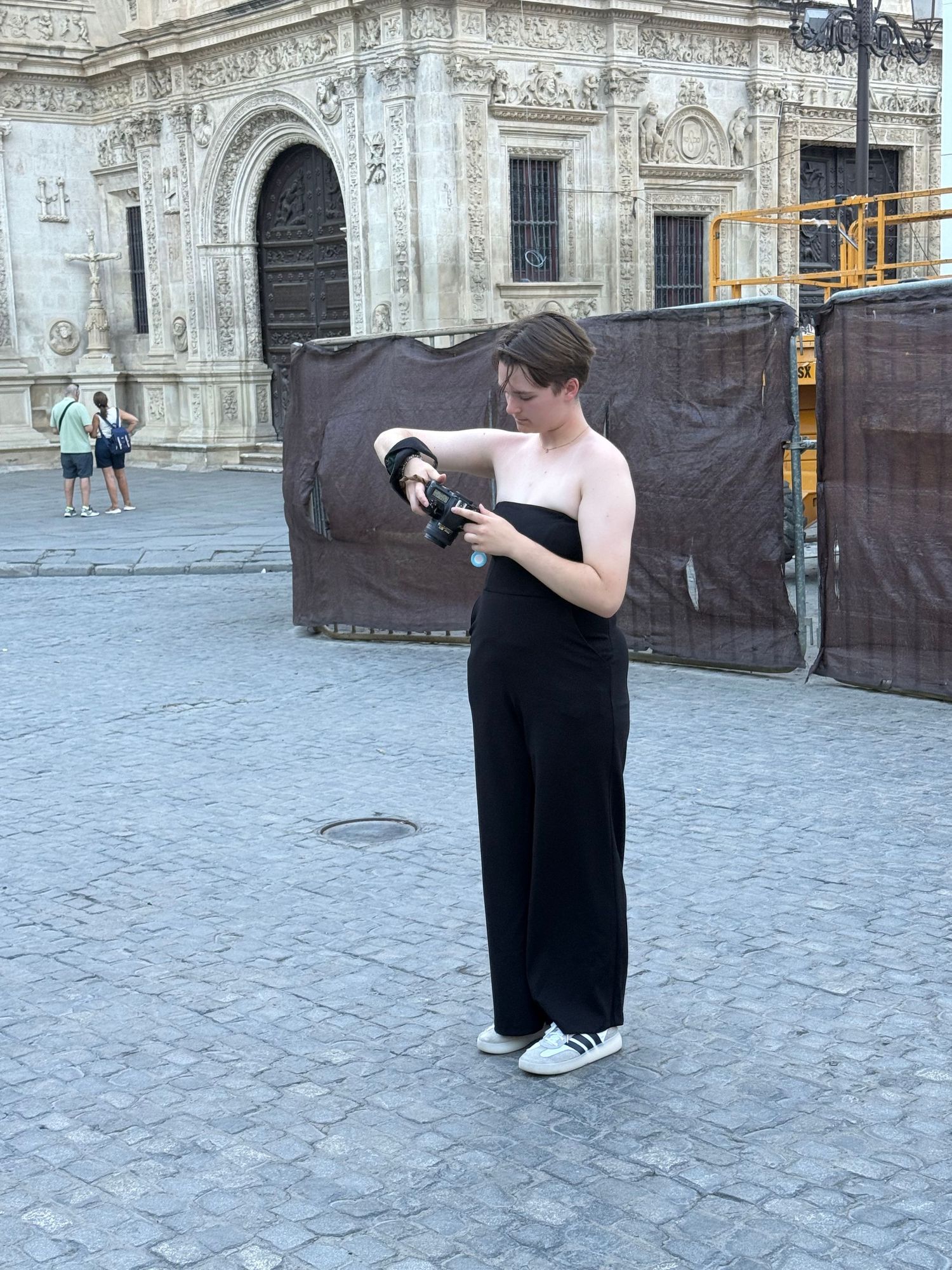 Photographer taking pictures in front of an ornate European cathedral facade.