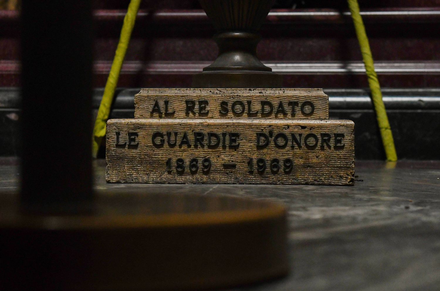 Historic memorial plaque with Italian text 'AL RE SOLDATO' and 'LE GUARDIE D'ONORE' engraved in stone.