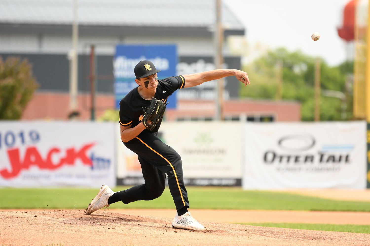 Baseball pitcher in mid-delivery motion on the pitcher's mound during game action.