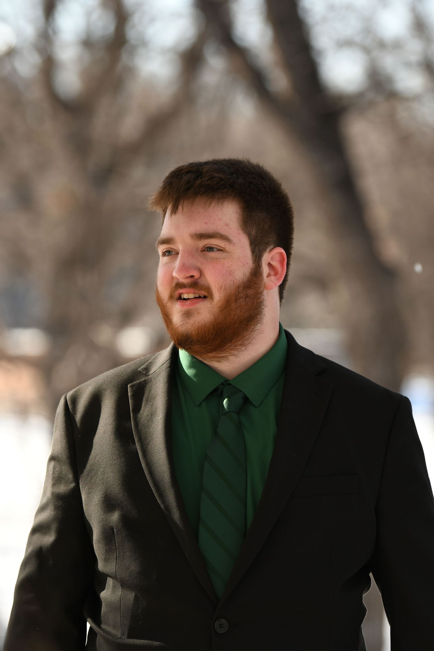 Portrait of a person in formal attire during winter with snowy background.