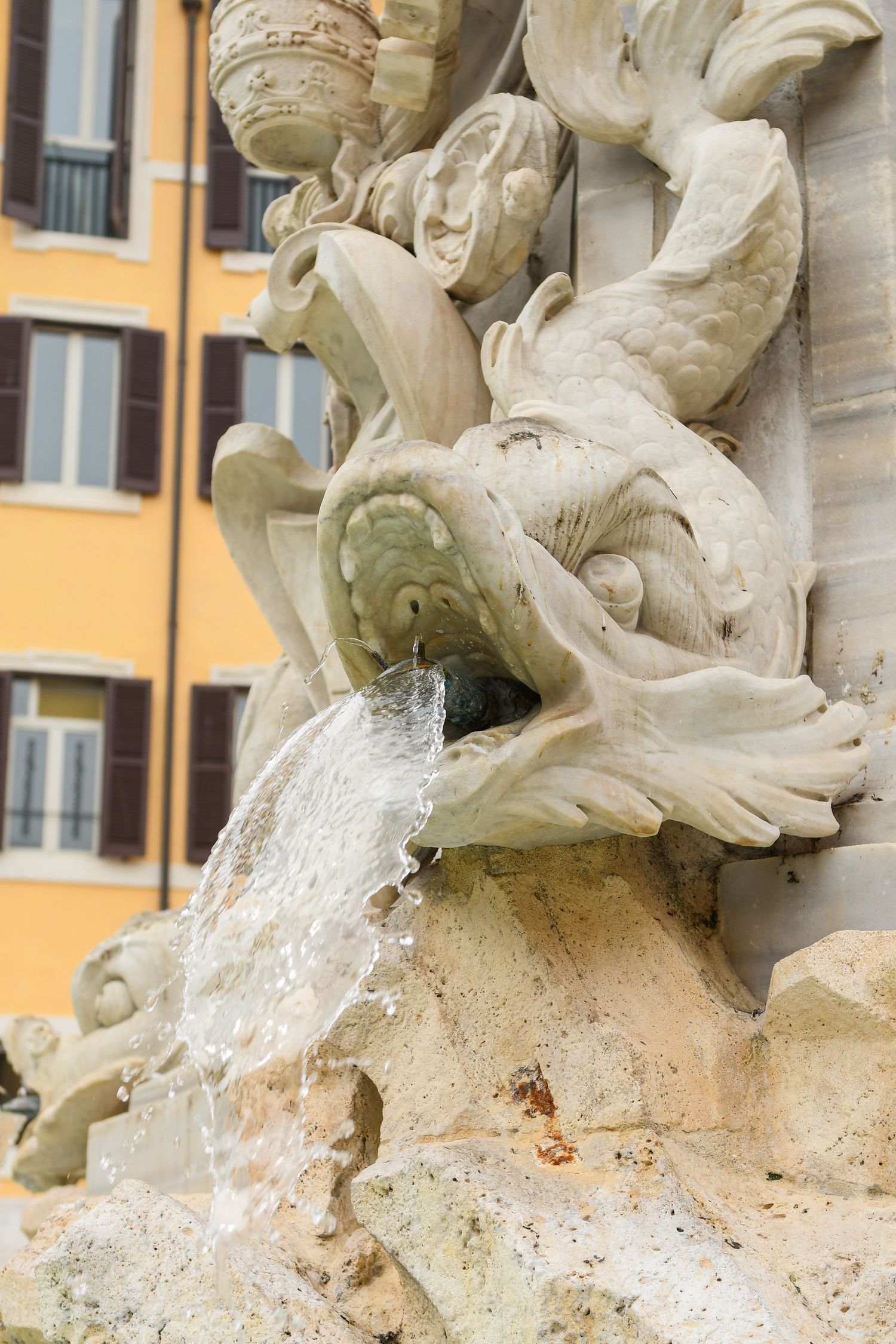 Ornate baroque fountain detail with water flowing from carved stone sculptures.