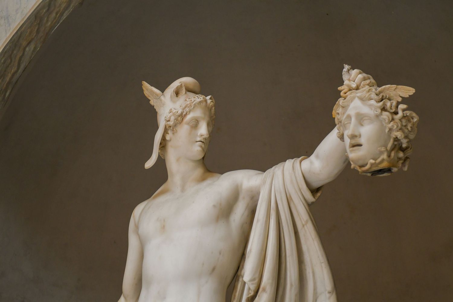 White marble sculptures of classical figures displayed in museum gallery.