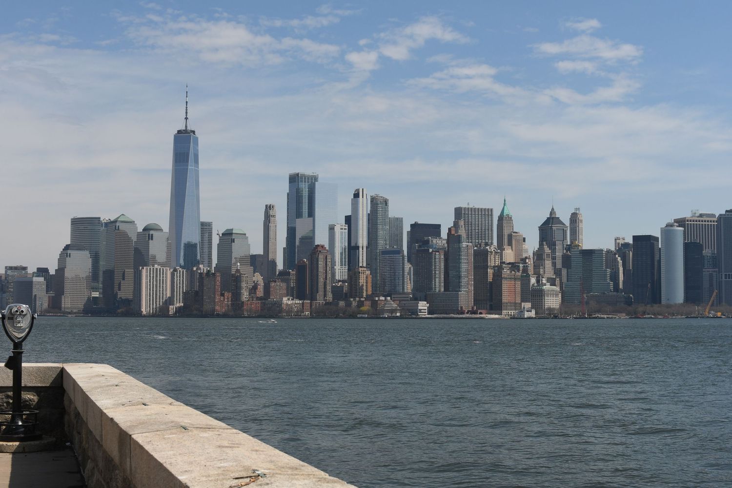 Manhattan skyline viewed from the water with One World Trade Center prominent in the vista.