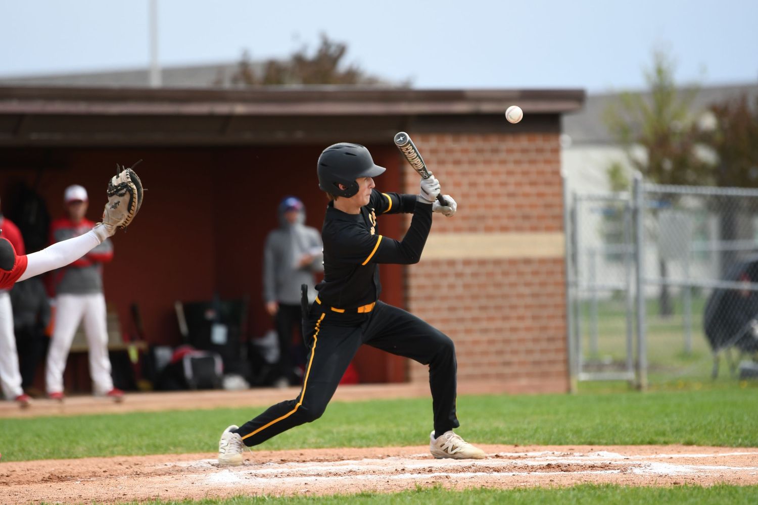 Baseball players in motion during competitive game on diamond field.