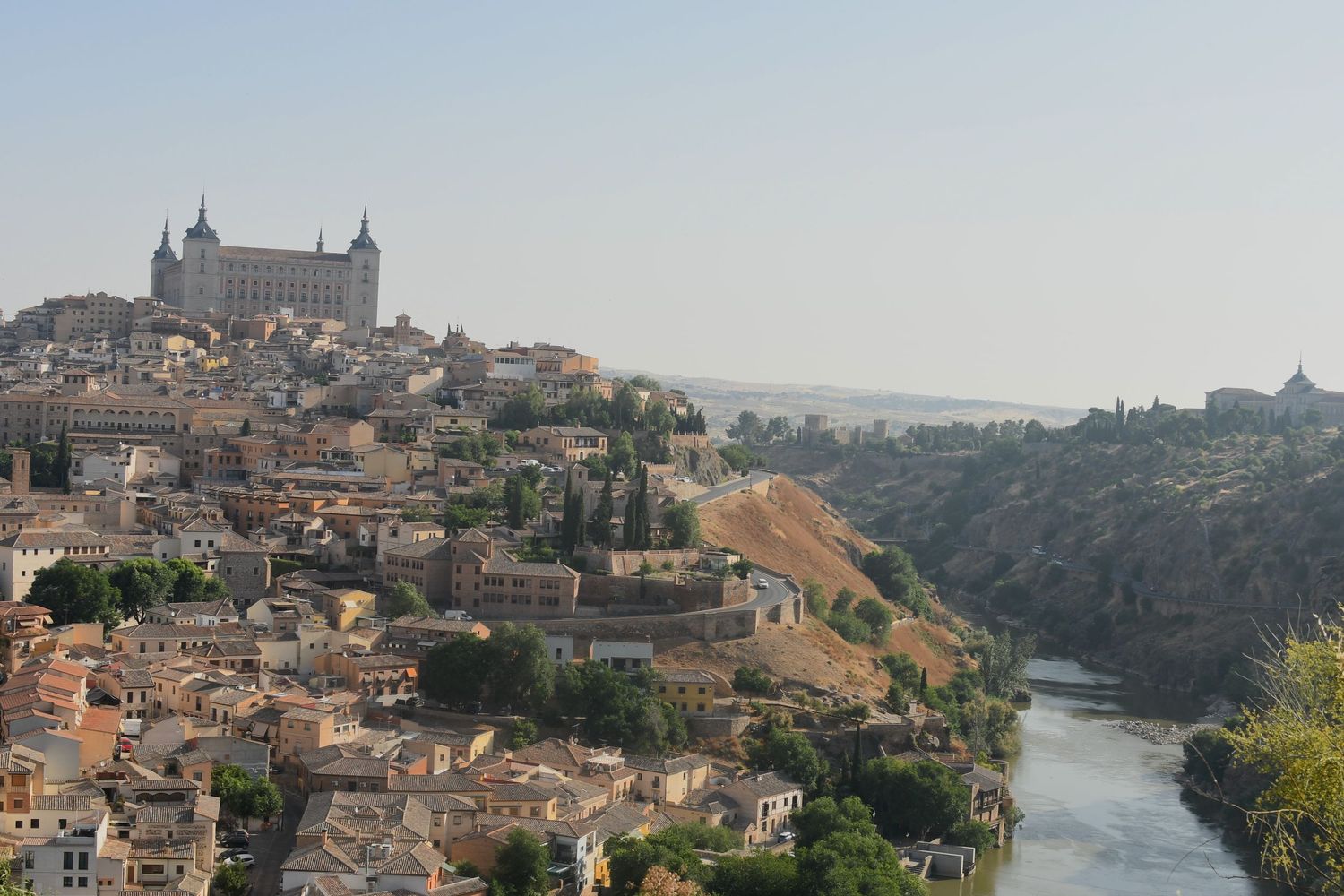Toledo cityscape with the Alcazar fortress perched on a hilltop above the Tagus River.