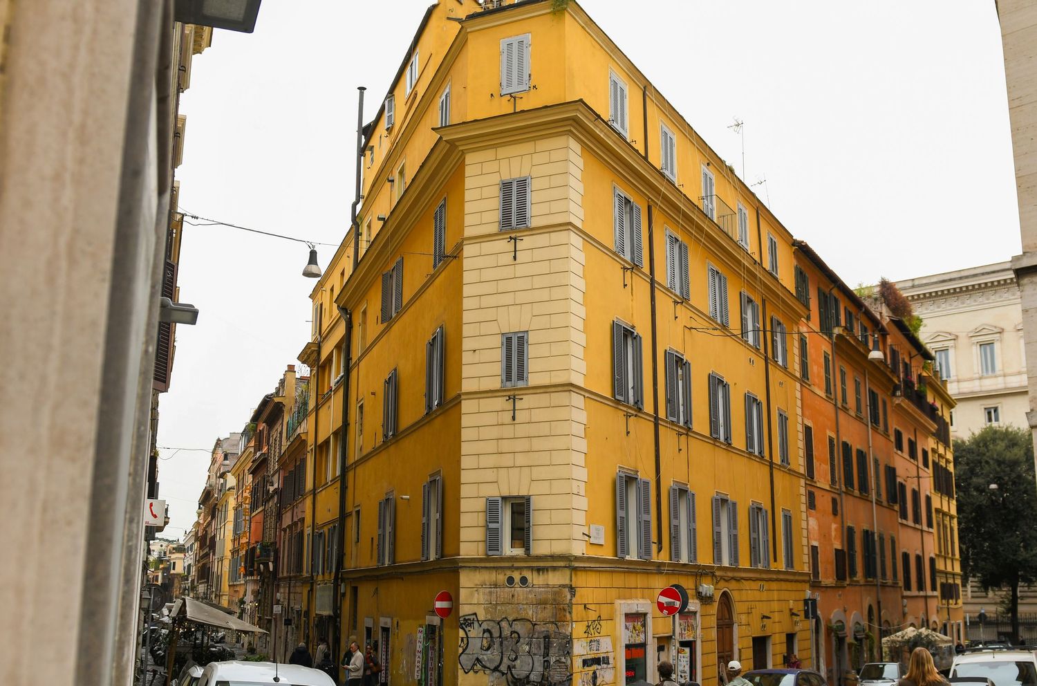 Bright yellow corner building with traditional Italian architecture in Rome's historic center.