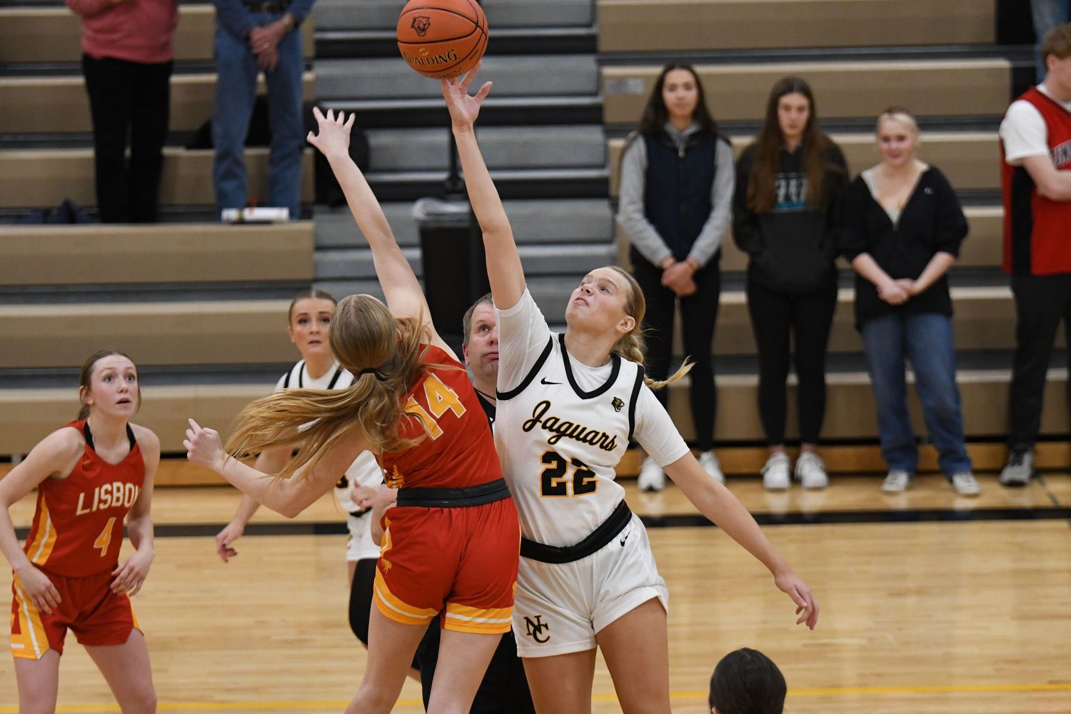 Basketball players from opposing teams compete for possession during intense game action.