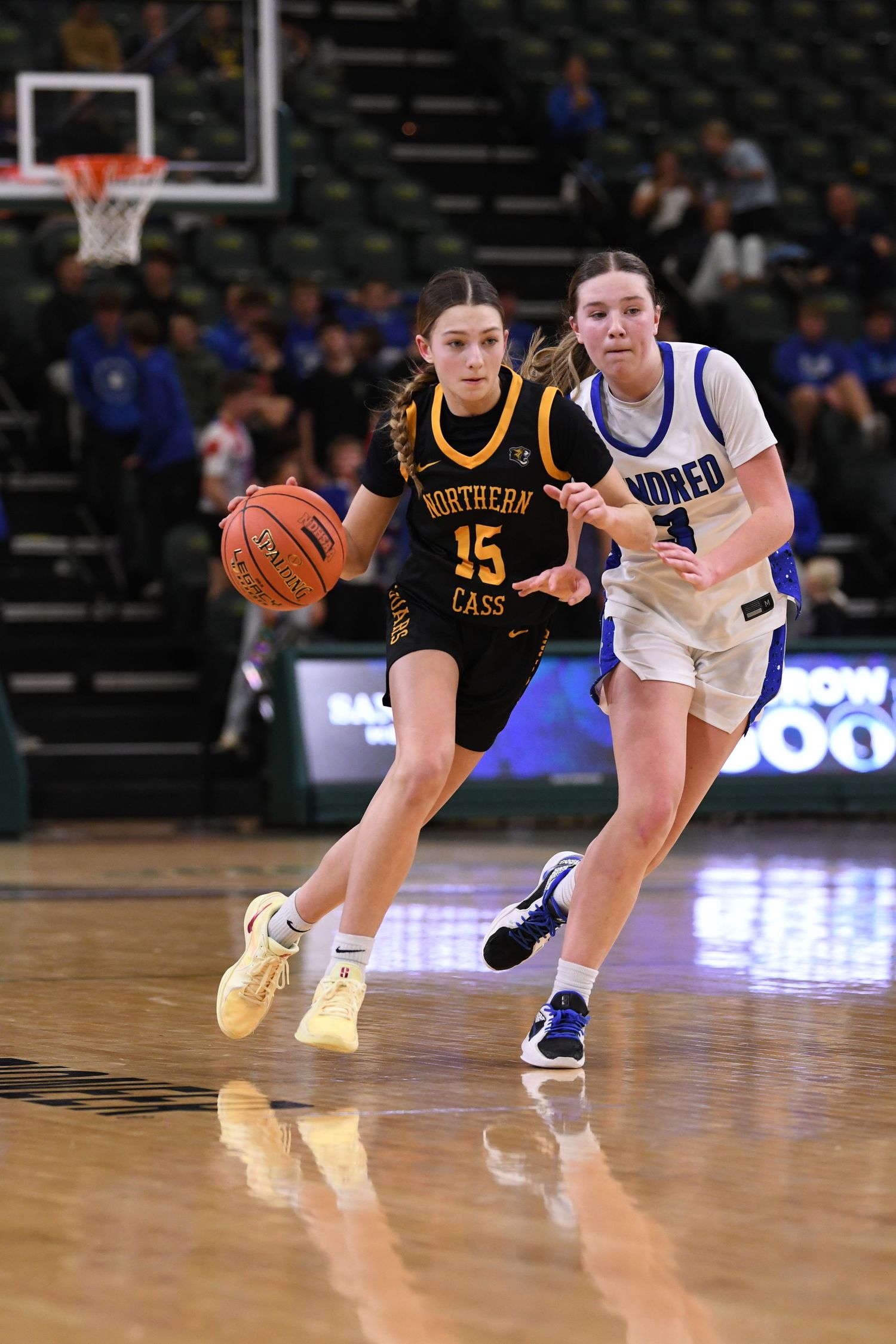 Basketball players from opposing teams battle for position during fast-paced game.