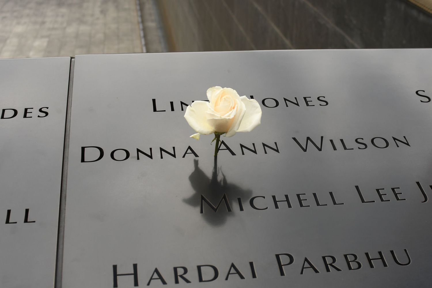 Close-up of engraved names on a dark memorial wall.