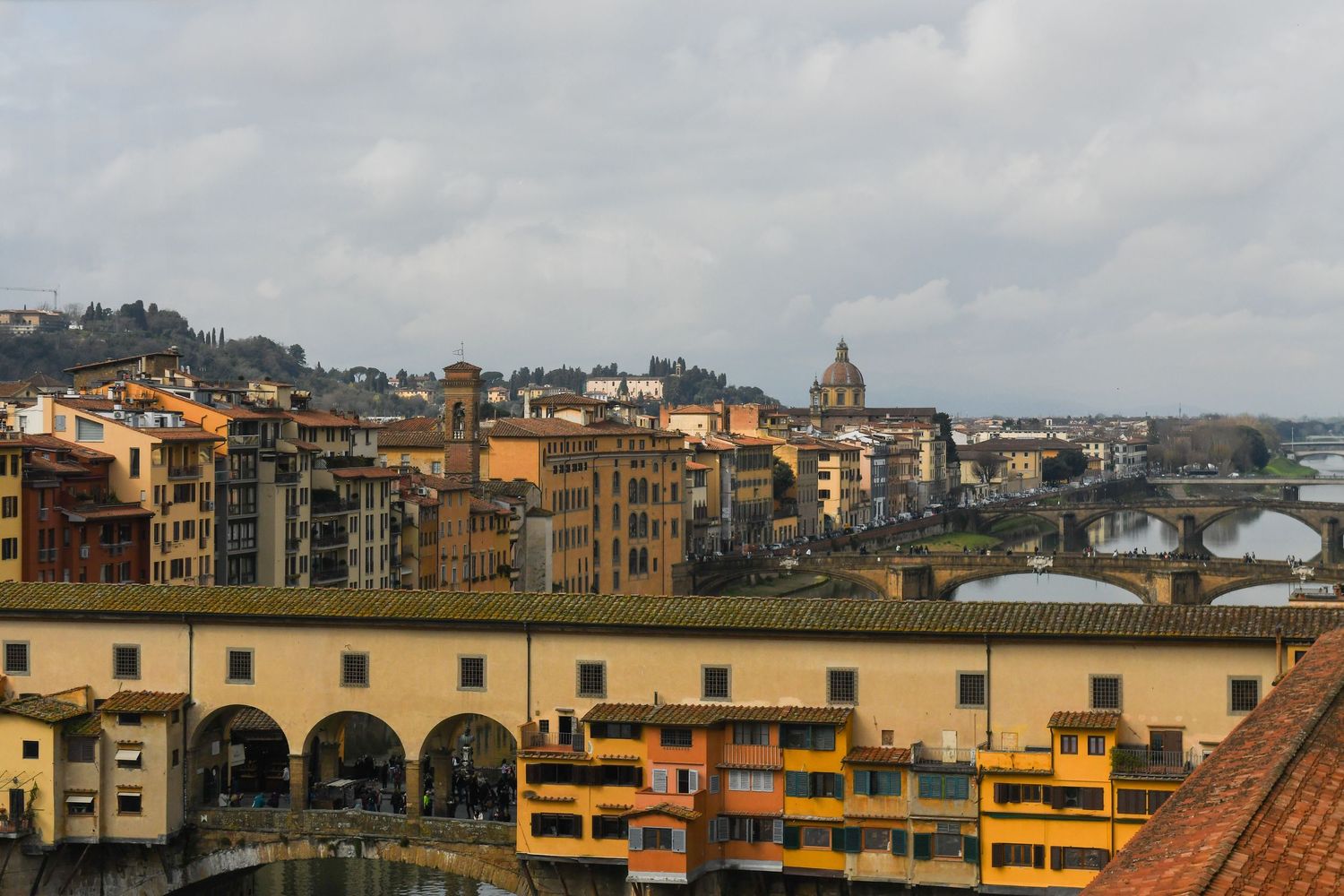 Panoramic cityscape view of Florence with traditional Italian architecture and bridges.
