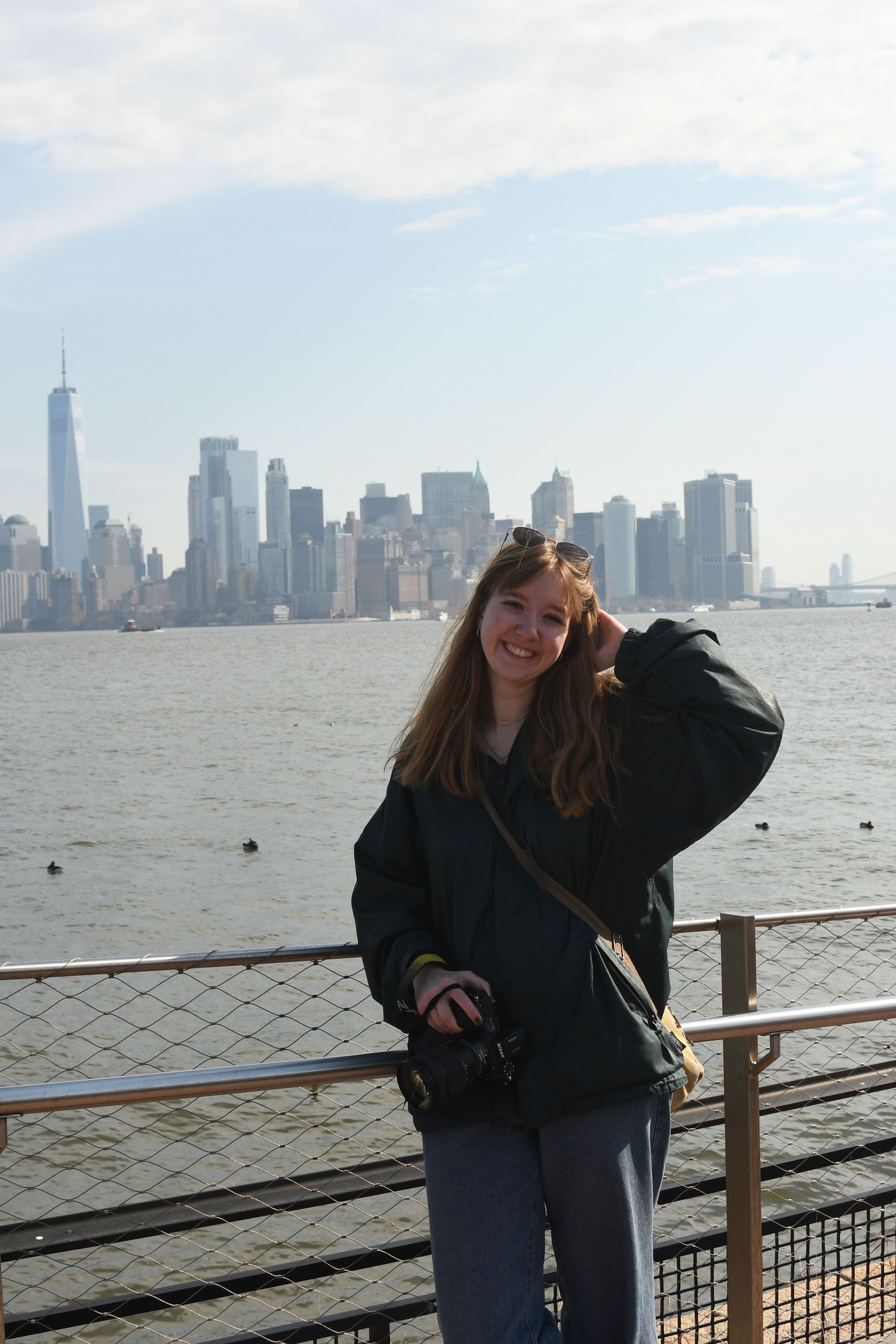 A series of photos at a waterfront railing with the Manhattan skyline visible in the background.