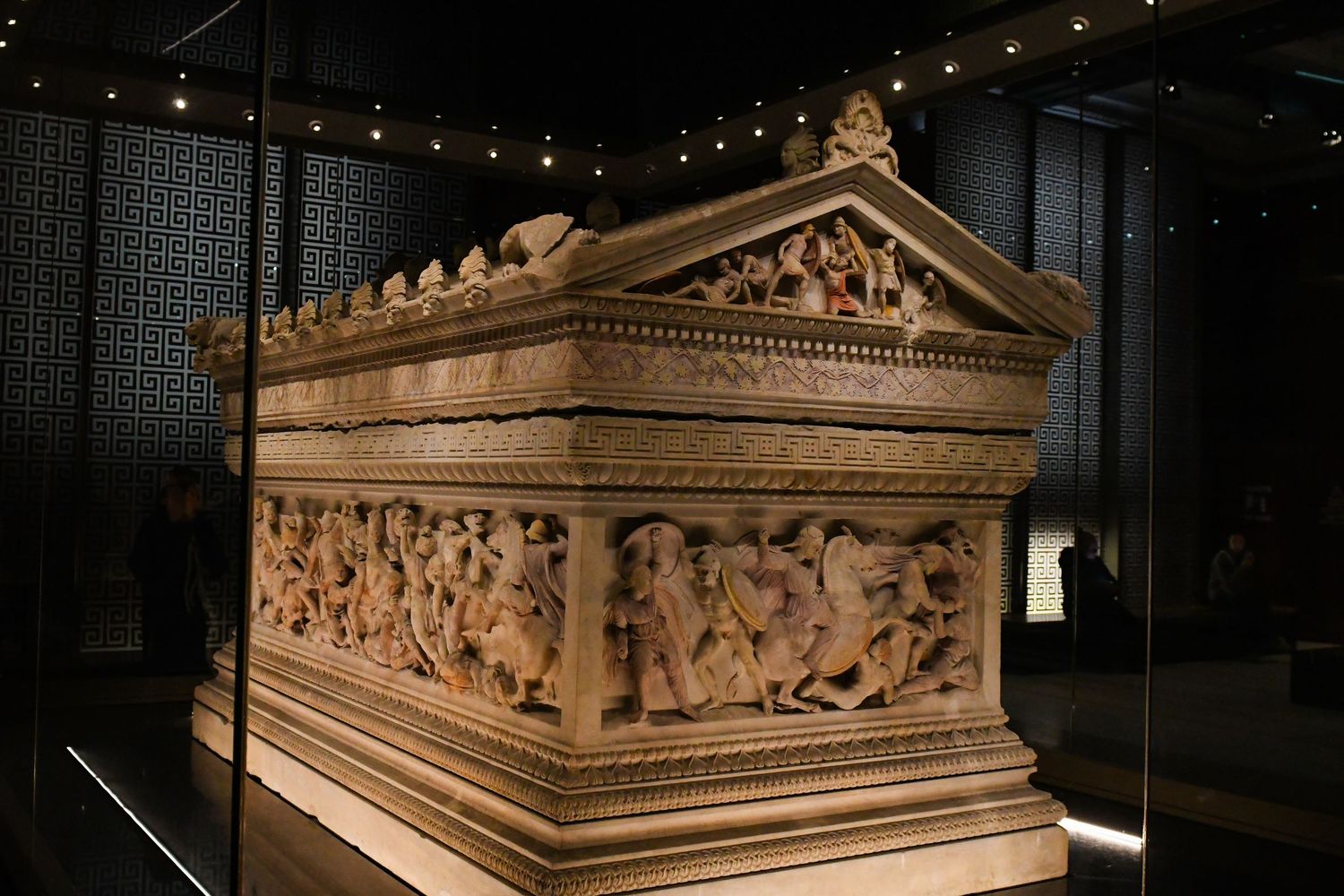Ancient marble sarcophagus with intricate carved reliefs displayed in museum lighting.