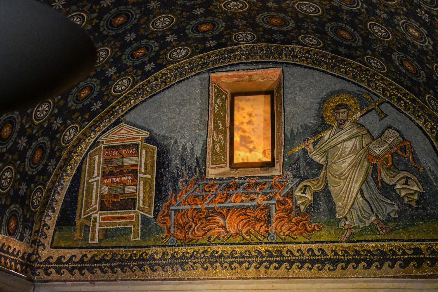 Medieval mosaic artwork depicting religious scenes along a church ceiling's curved arch.