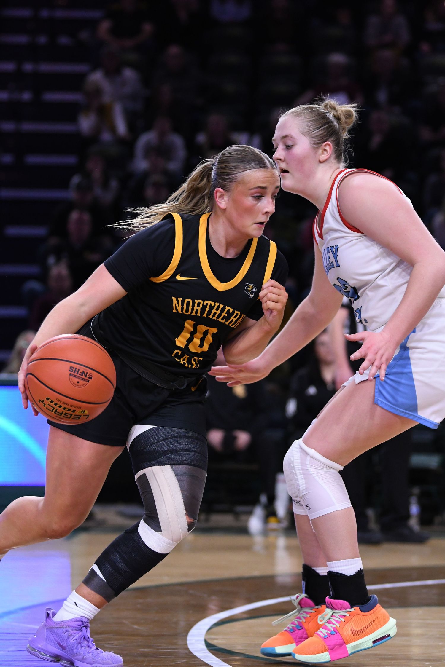 Athletes battle for possession during intense basketball game.