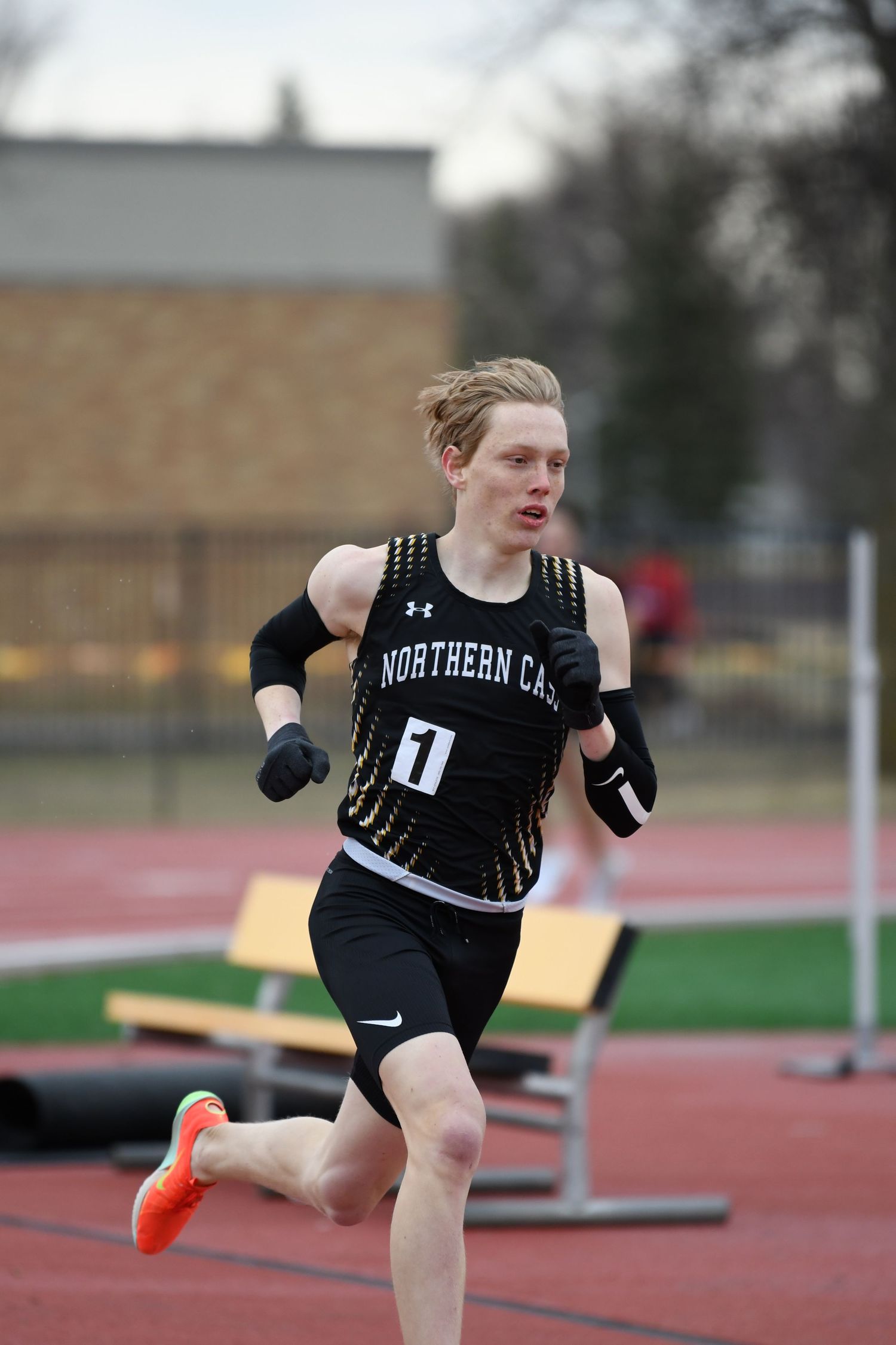 Track athlete demonstrates strong form during long jump practice at outdoor facility.