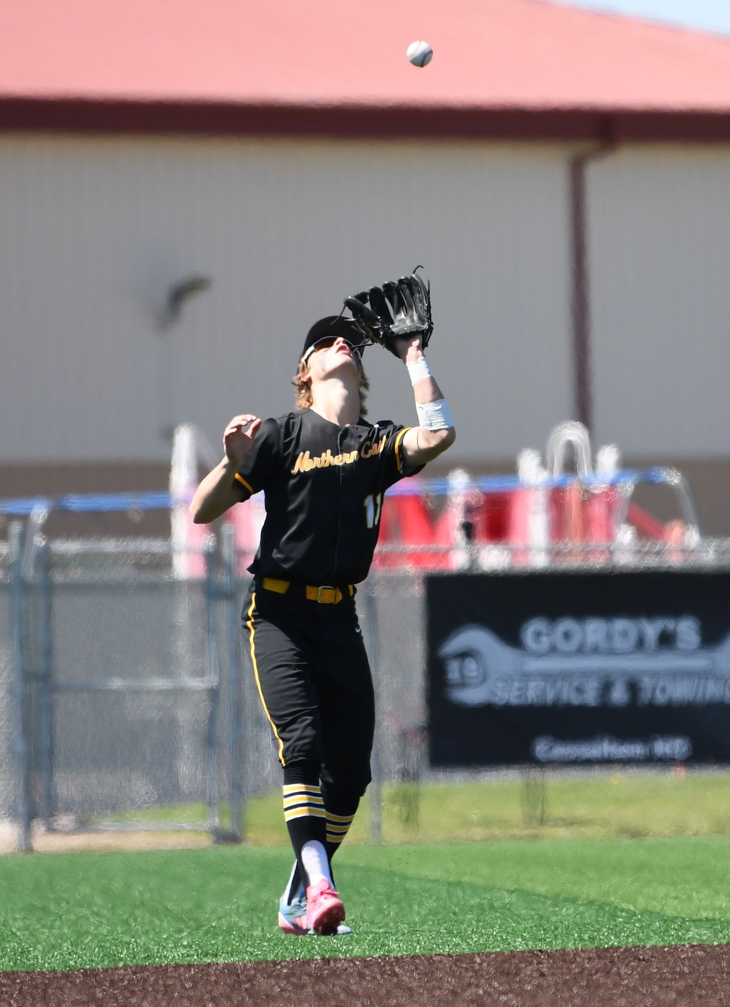Baseball infielder prepares to field a ground ball on the infield dirt.