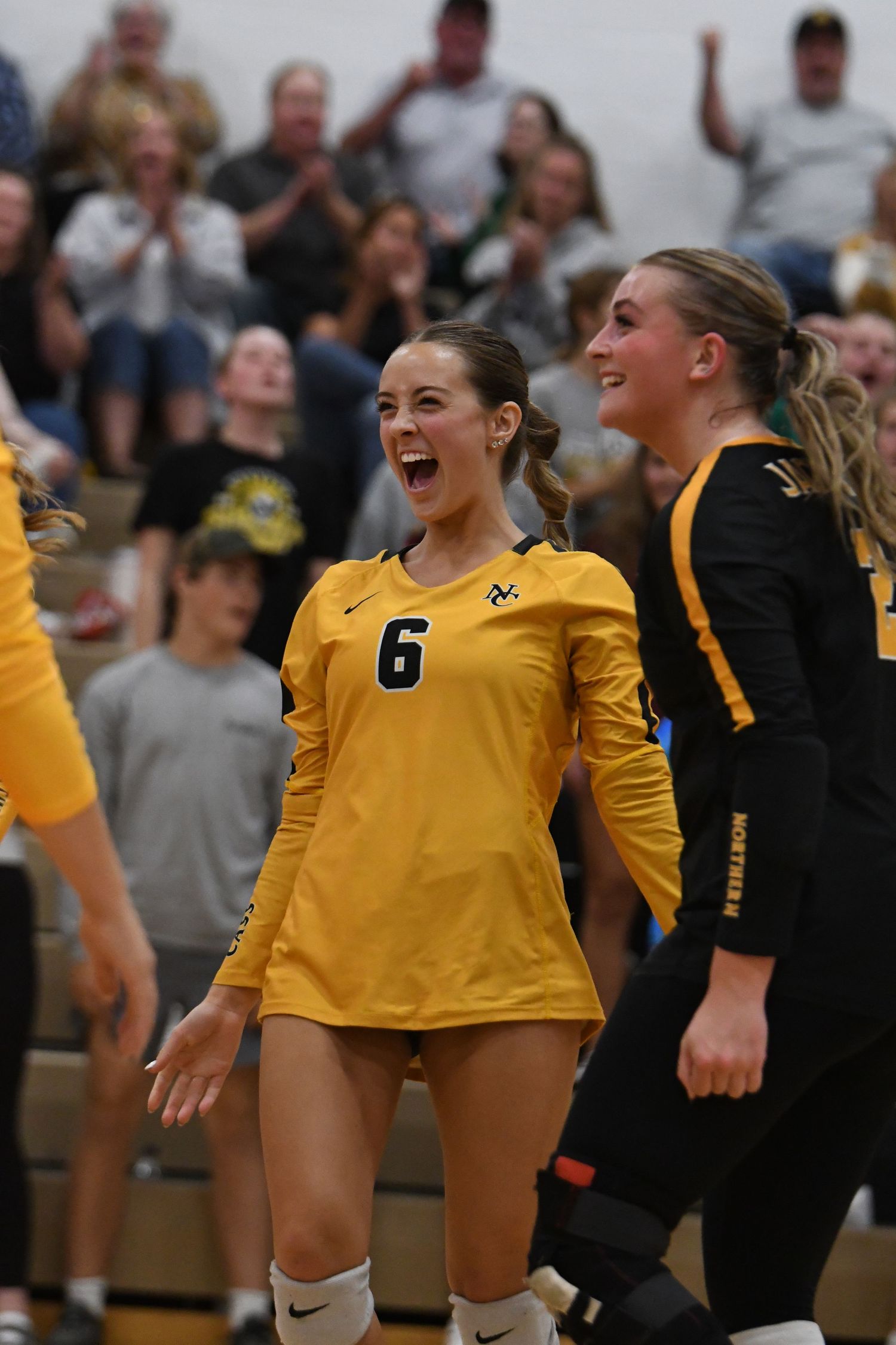 Volleyball players show excitement and team spirit during a match celebration.