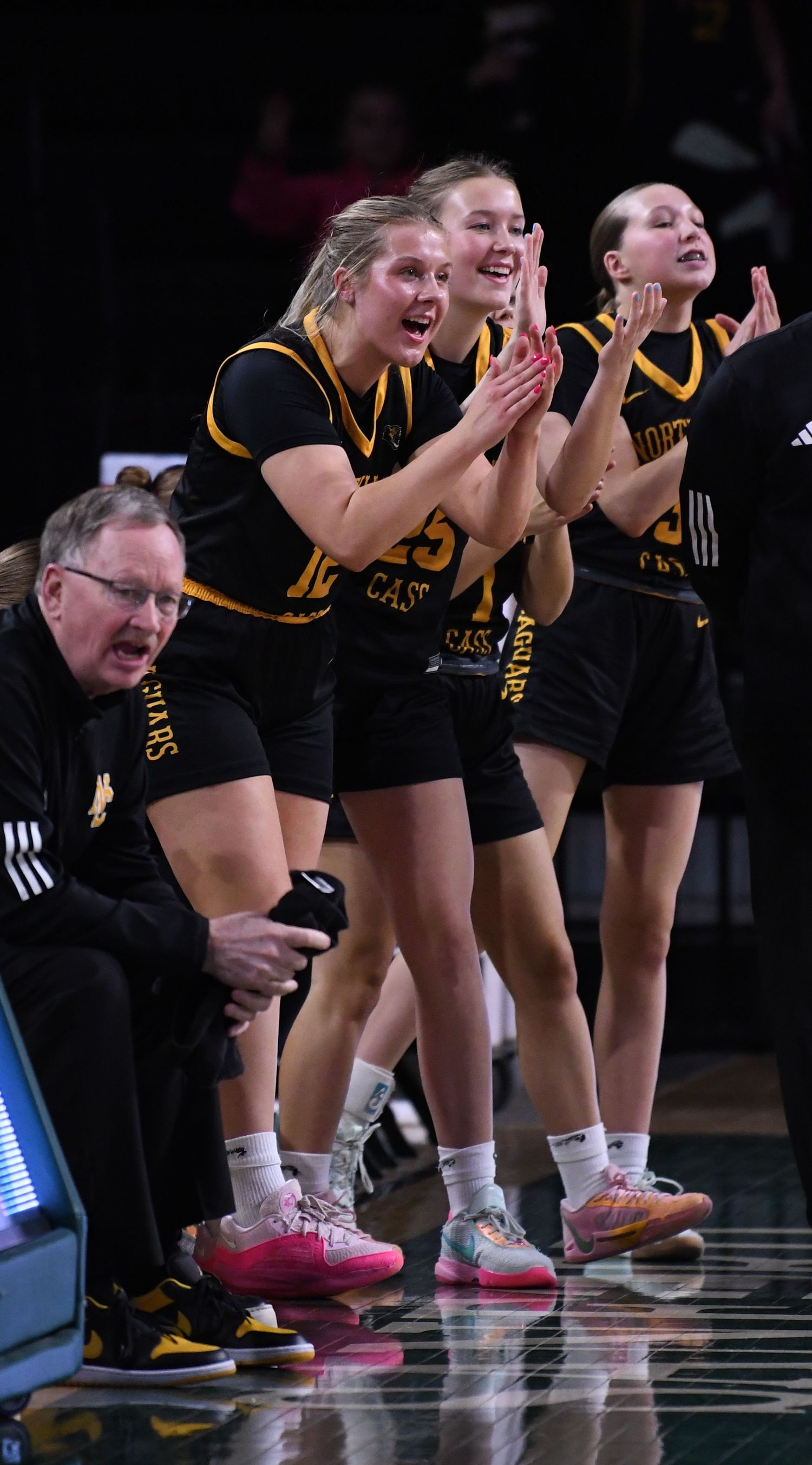 Team bench shows intense emotion while watching basketball game.