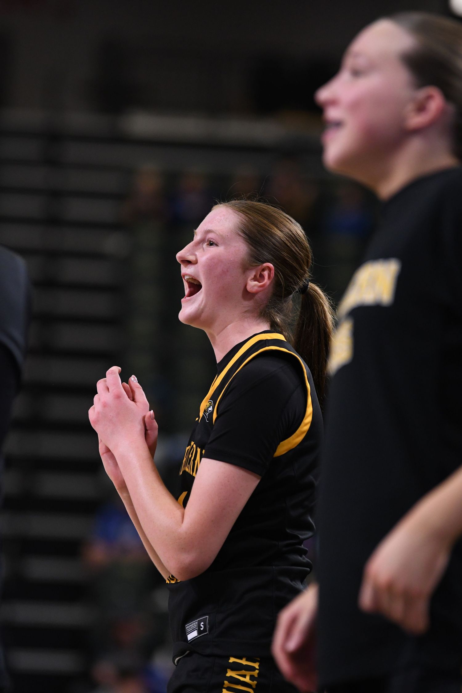 Players in black jerseys celebrate enthusiastically during basketball game.