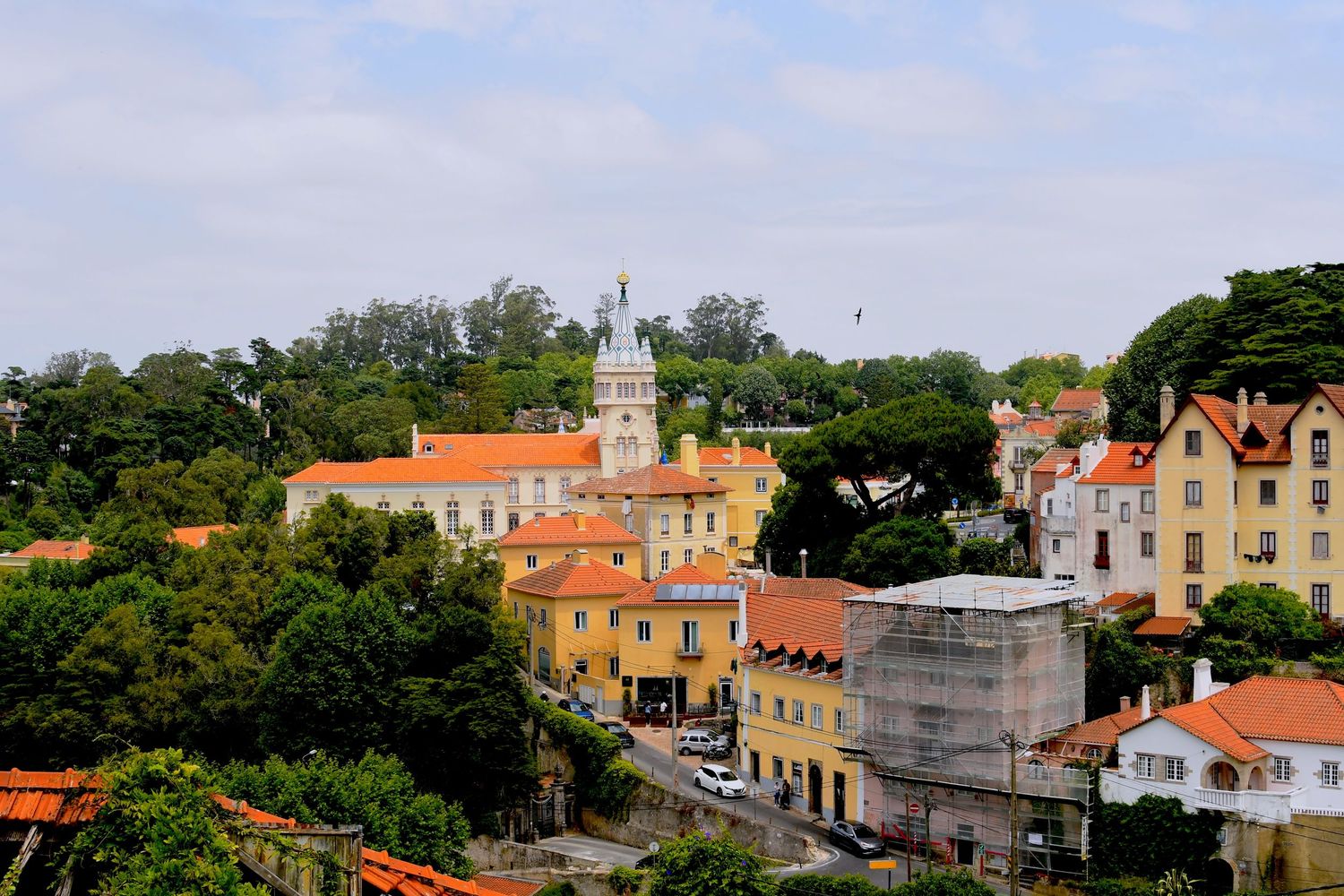 Panoramic view of a historic coastal town with colorful buildings and red-tiled roofs.