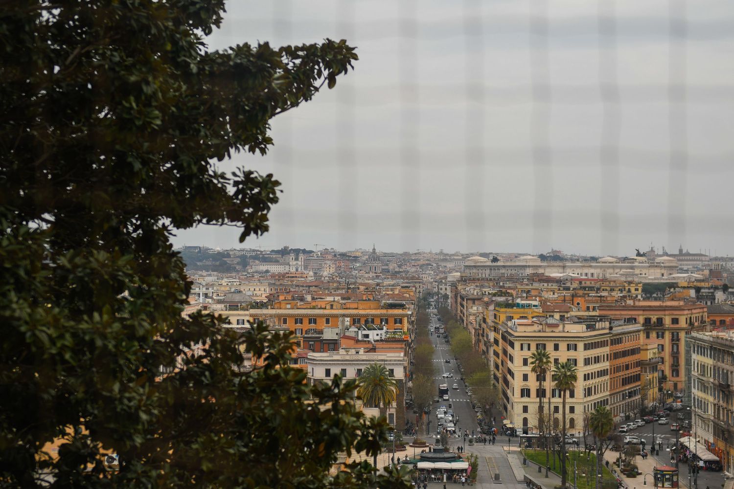 Panoramic cityscape view of Rome with urban buildings stretching to the horizon.