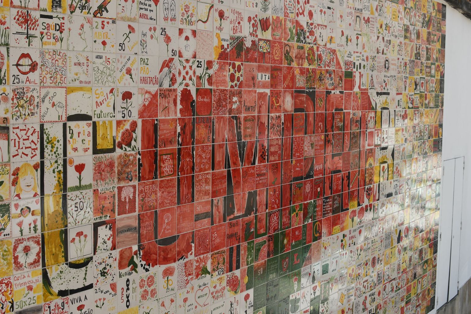 Urban street art featuring a large red graphic design on a graffiti-covered wall.
