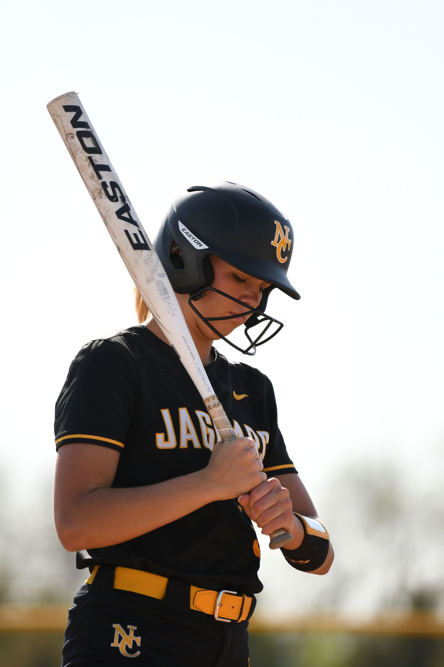 Softball batter in Jaguars uniform takes practice swings against white background.