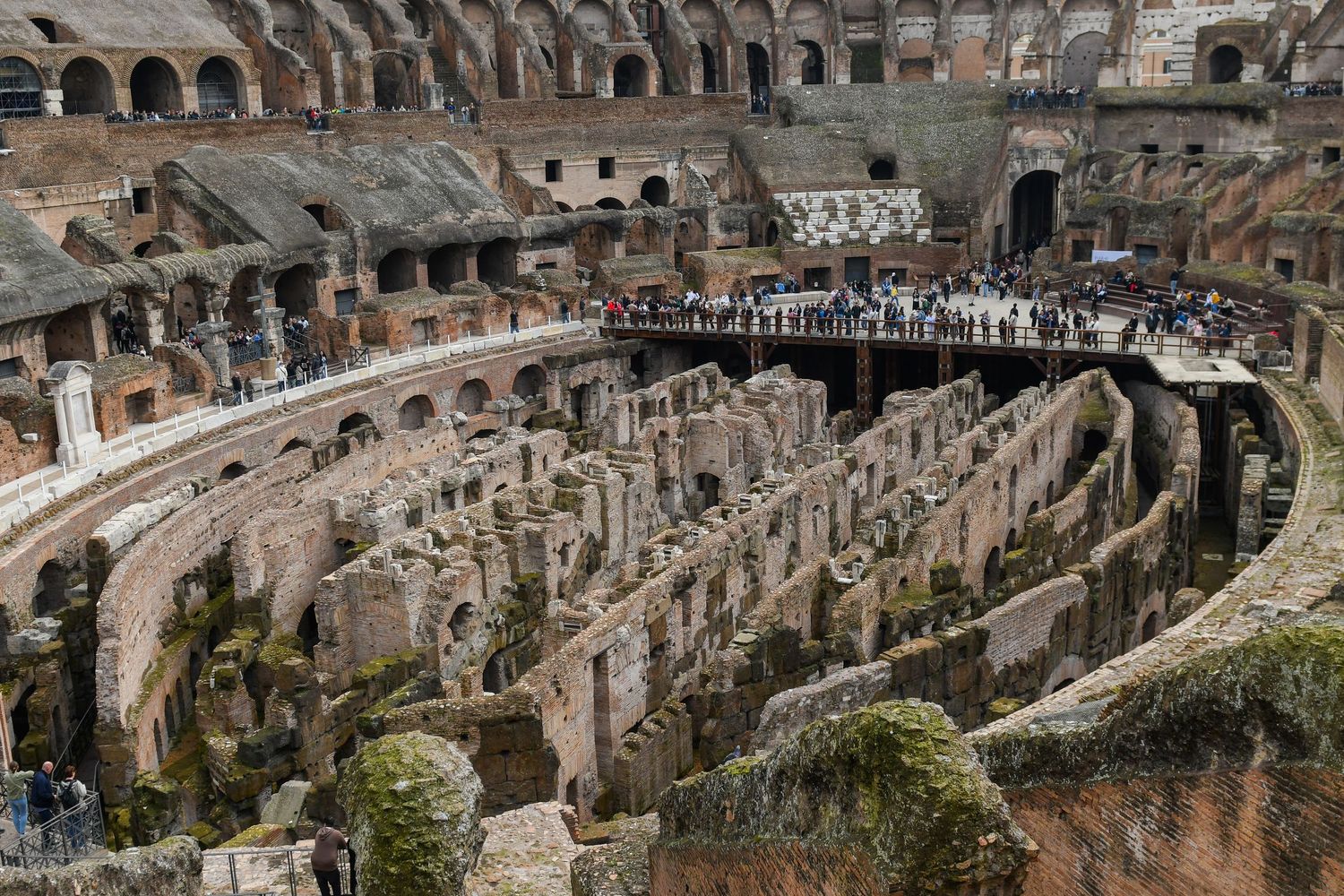 Ancient Roman Colosseum interior showing multiple levels of arches and architectural details.