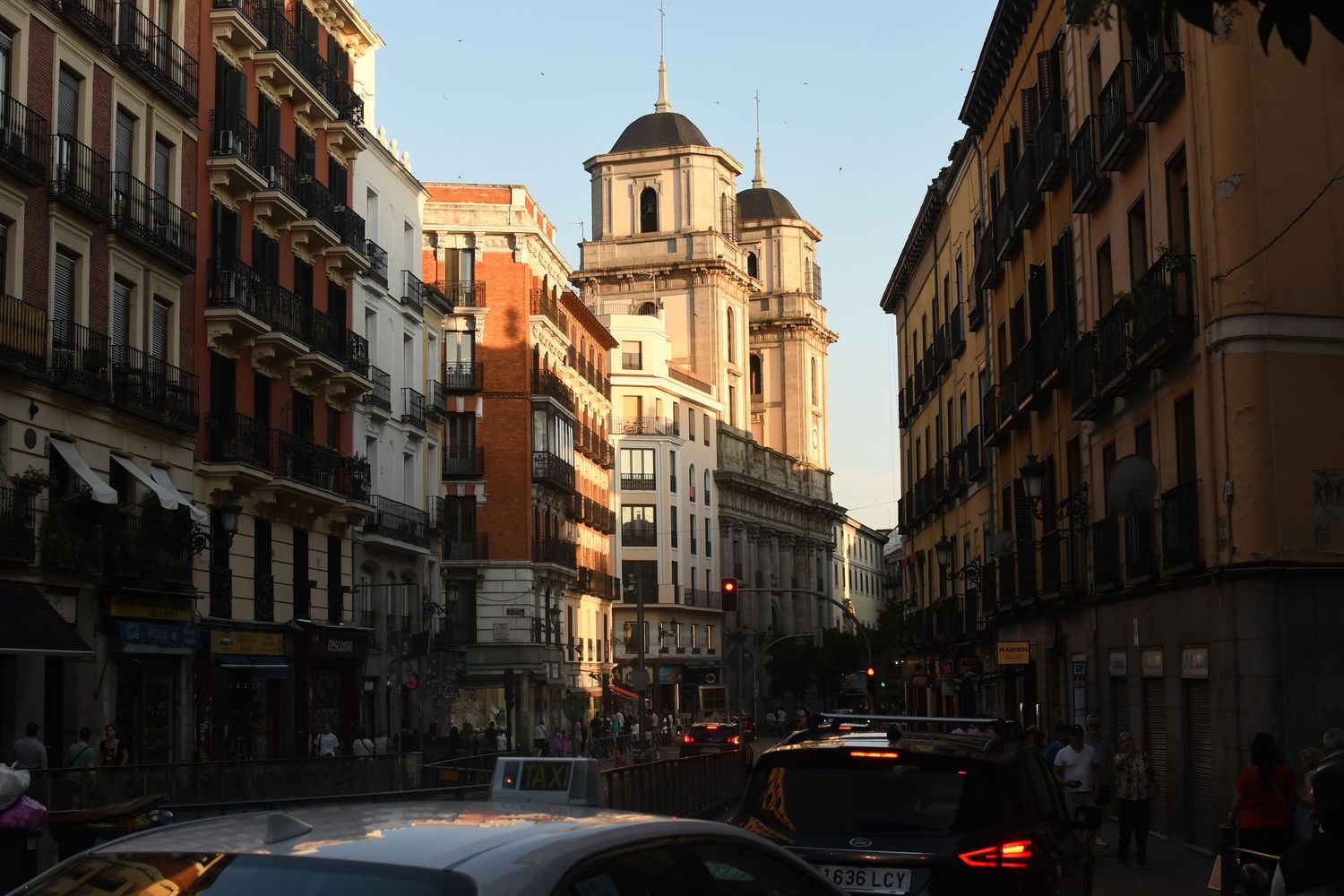 Historic Madrid street scene with baroque church dome and traditional apartment buildings.